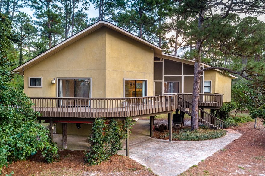 Adorable, modern style home located on a wooded lot with fantastic views of Oyster Lake and the Gulf! Ground level is a carport, large storage or workspace, and air-conditioned cedar wine cellar. Second level is the main house with a spacious open concept kitchen, dining and living area, complete with Corian countertops, stainless steel appliances, kitchen island, pantry, vaulted ceilings and fireplace. The second level also features a split bedroom floor plan allowing more privacy and comfort for the master suite. Enjoy beautiful lake views from the master suite bedroom or from its balcony. The master suite bath boasts gorgeous Carrera marble and a steam shower! The additional bedroom and bathroom are located on the other side of the indoor living area. Wooden decks wrap around