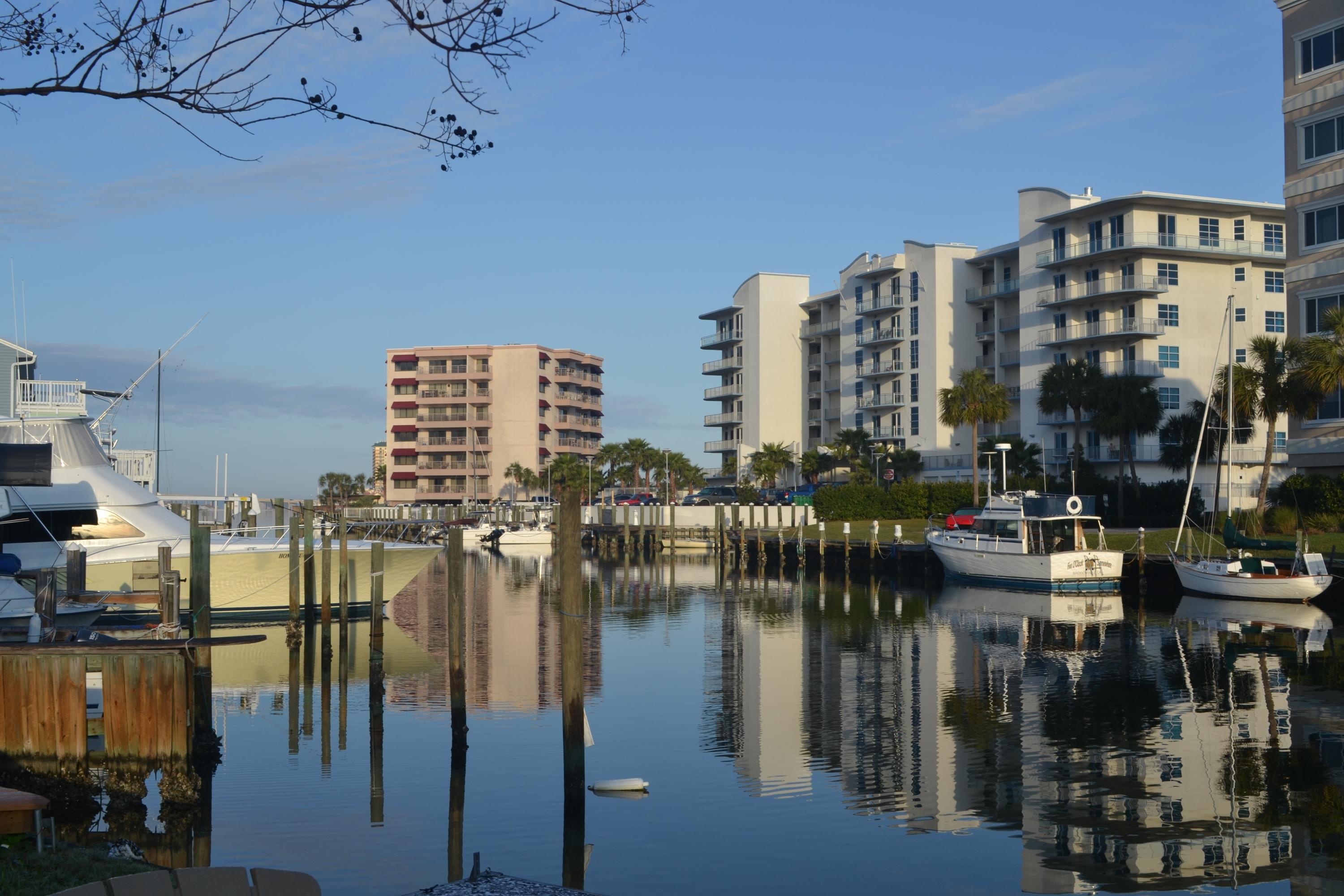 Bright and spacious Holiday Isle townhome with water access to Destin harbor and steps away from the best sugar-white beaches on the emerald Coast. Two huge master bedrooms each with dual-vanities and large walk-in-closets. Stunning new hardwood flooring throughout, plus fresh paint and updated fixtures. Superb open concept living with towering 18-foot ceilings, convenient 1/2 bath, large loft/office, bonus storage area and relaxing private backyard deck. Inviting common area overlooking canal with fire pit, floating boat dock and Adirondack chairs, perfect for entertaining and catching the water taxi to Harborwalk Village. Tastefully furninshed for a move-in ready holiday home or customize it to your taste!