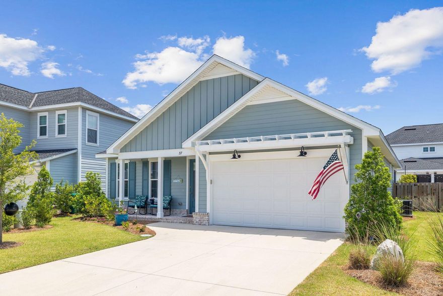 This charming coastal cottage is on a quiet cut-de-sac in Watersound Origins. Park your vehicle on the double-wide driveway leading to the two-car garage and pause to admire the heirloom brick flooring on the covered front porch. Well maintained and attractively presented, this beach retreat is laid out all on one level. It has fresh neutral decor, large windows and LVP flooring throughout. The open living space has a spacious sitting area at one end that is flooded with natural light. On one side there's a defined formal dining nook with feature lighting for entertaining. Heading toward the kitchen, a huge quartz-topped island with four bar stools is tailor-made for enjoying cocktails and snacks before dinner.