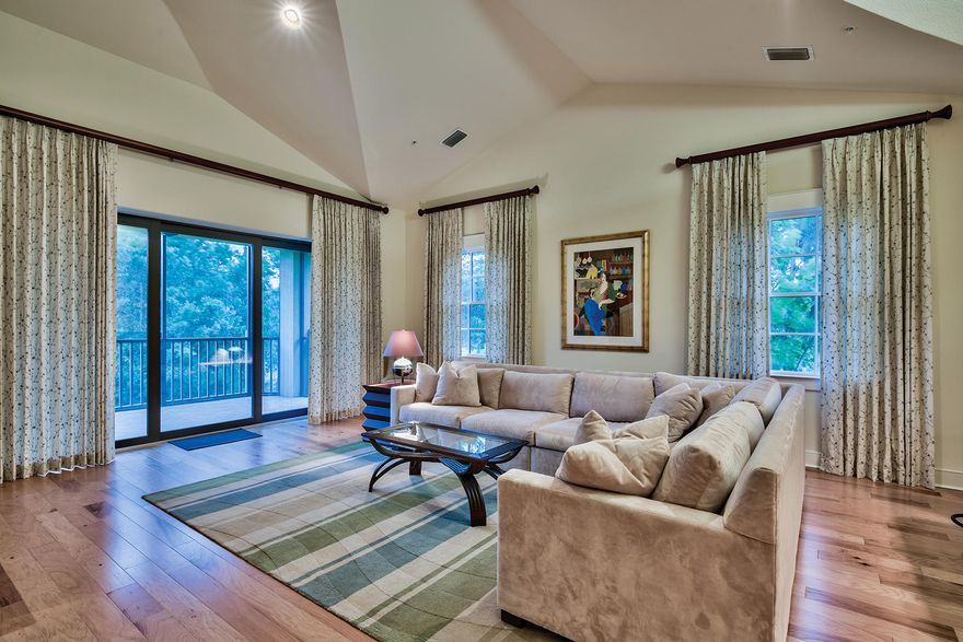 Backing up to the 9th tee of the Greg Norman-designed Shark's Tooth Golf Course is this second floor Clubside townhome at Wild Heron. Enjoy private elevator access from the enclosed two-car garage at ground level to the lofty living areas, nearly all of which feature vaulted or cathedral ceilings. Wide cut wood floors found throughout the principal living areas, built-in banquette seating in the eat-in kitchen, and craftsman-style accent lighting create a cozy environment more akin to a single family home. Unlike their ground floor counterparts, second floor Clubside units include a bonus room with double entry doors, a private bath, and walk-in closet, as well as an expanded den or home office area referred to as the 19th hole.