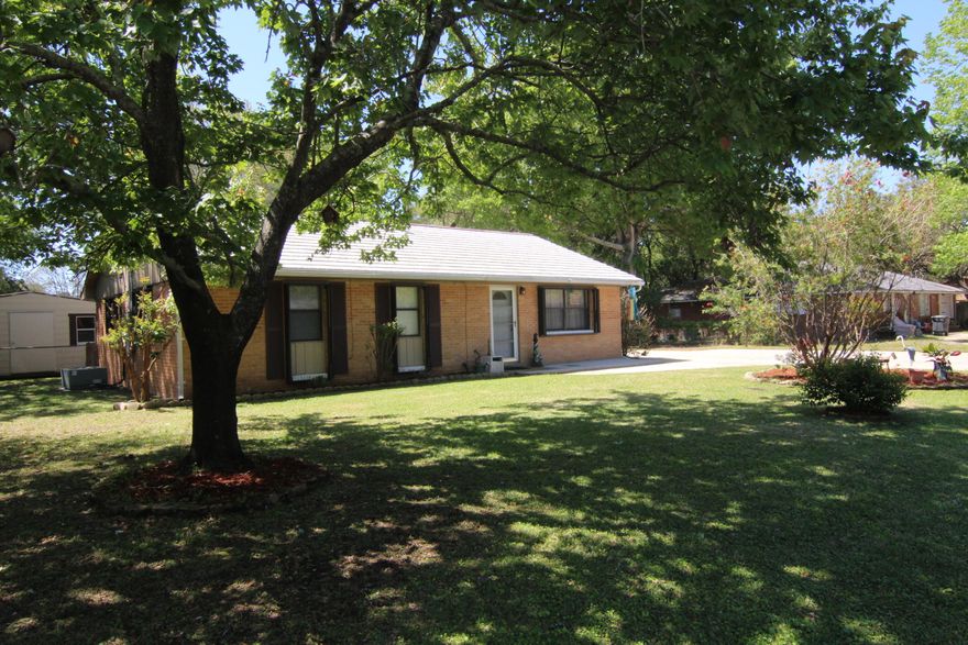 What a deal! This is a well maintained home in a great location. Right away you will notice the mature oak trees and lush green grass that give this home its awesome curb appeal. There is an over sized driveway and an additional parking pad for a RV complete with electrical service and sewer access. Inside the home you will love the open floor plan that makes the home great for entertaining. The living room is quite large and fills with natural light during the day. The kitchen has maple cabinetry and ceramic tile giving it a very polished look. There is a large laundry room that has room for additional storage, or a chest freezer. The additional bedrooms are good size and have wood laminate flooring. The master bedroom is finished out with carpet giving it a cozy feel.