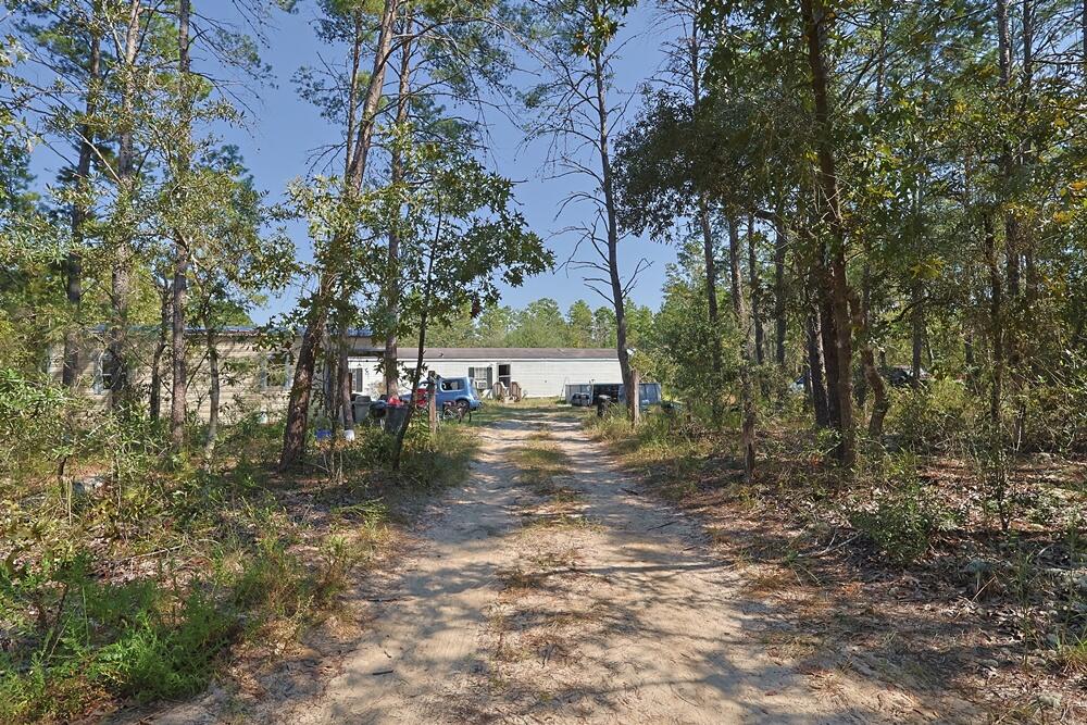 Freeport 5-acre parcel with 3BR/2BA mobile home (2000). Wooded setting near a creek on a quiet dead-end country road with multiple access points from J W Hollingston Rd. Home is occupied and sold in need of a full rehab; roof and appliances appear original (2000). Value may be in land and potential--bring your contractor or builder. Ample space for trails, gardens, or storage (verify uses with county). Showing by appointment only; please do not disturb occupants. Buyer to verify all measurements, access, utilities, flood/soil, and all pertinent information.