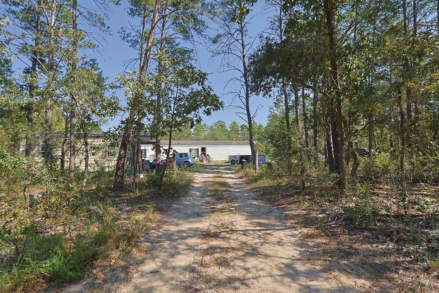 Freeport 5-acre parcel with 3BR/2BA mobile home (2000). Wooded setting near a creek on a quiet dead-end country road with multiple access points from J W Hollingston Rd. Home is occupied and sold in need of a full rehab; roof and appliances appear original (2000). Value may be in land and potential--bring your contractor or builder. Ample space for trails, gardens, or storage (verify uses with county). Showing by appointment only; please do not disturb occupants. Buyer to verify all measurements, access, utilities, flood/soil, and all pertinent information.