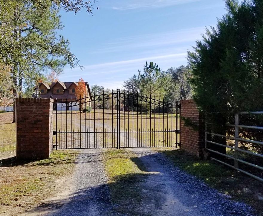 5.83 fully fenced acres! Main house is brick with a metal roof. Constructed in 2009, 2 bed, 2 bath 1769 sf open floor plan lives large. Spacious kitchen has granite countertops, an island with a vegetable sink, all stainless appliances. Great room has a vaulted ceiling and wood burning fireplace. Laundry/mud room leads to the screened and covered back porch. Large Porches both front and back. Covered walkway from house takes you to the cypress sided 2 car garage. Above the garage is a 1 bed 1 bath guest suite. Built in 2006 when the garage was constructed, boasts 848 sf with a full kitchen and living area. There is also a heated/cooled exercise room/office and laundry hookups on the garage level. Gutters drain into water saving rain barrels! Pole barn, Greenhouse, Poultry coop and a pond.