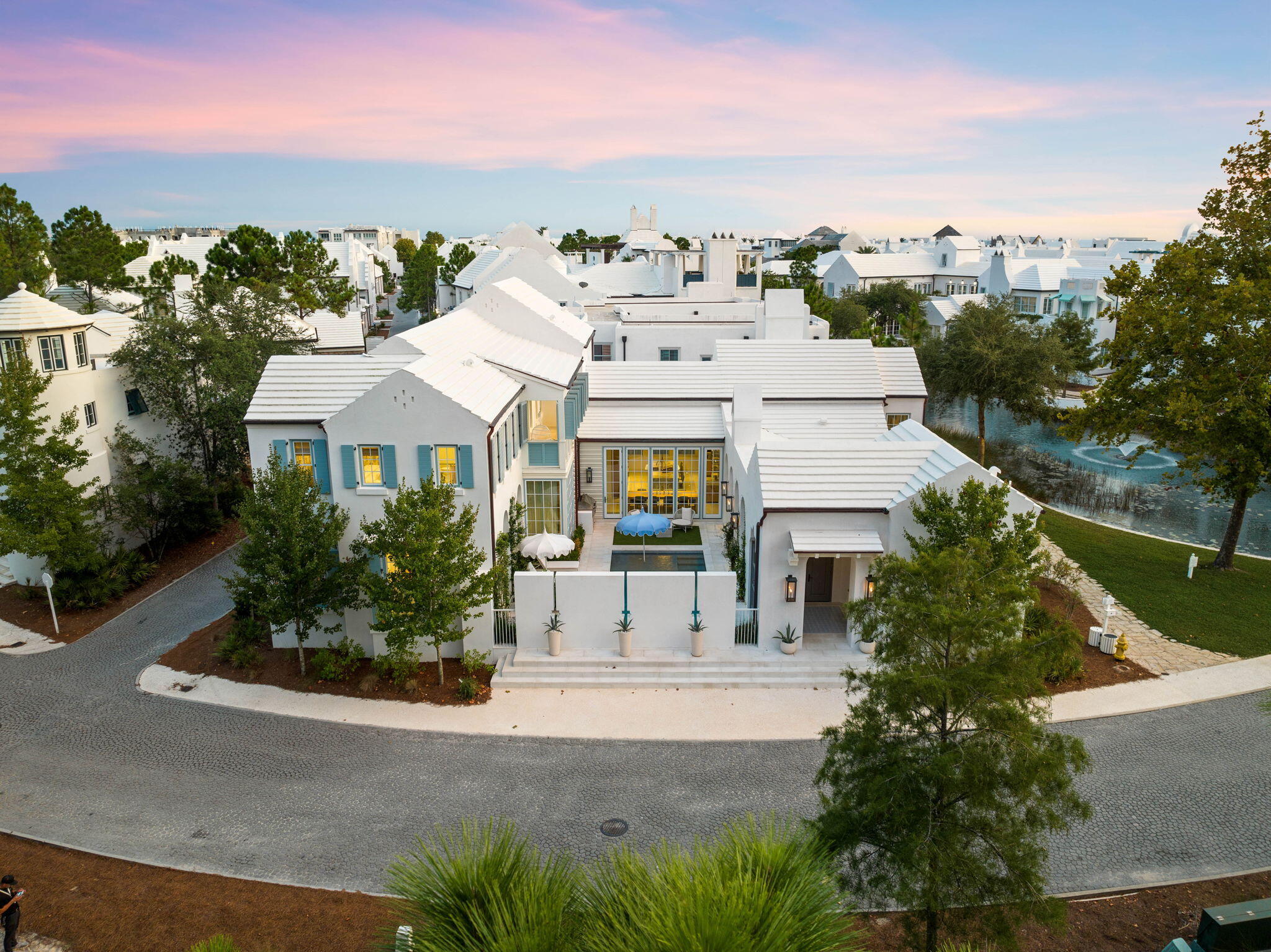 Nestled within the especial community of Alys Beach, 285 N Somerset Street stands as a timeless masterpiece of coastal luxury and elegance whilst channeling the captivating blend of Greek-inspired architecture, artistic elegance, and fortified construction. Upon initial approach, the cobblestone drive and gas lantern-lit entry lead way to the true four-season living corridor lined with bi-fold doors while providing seamless access to the main residence which spans over five thousand square feet in addition to the courtyard, dedicated outdoor dining area, and separate guest quarters.