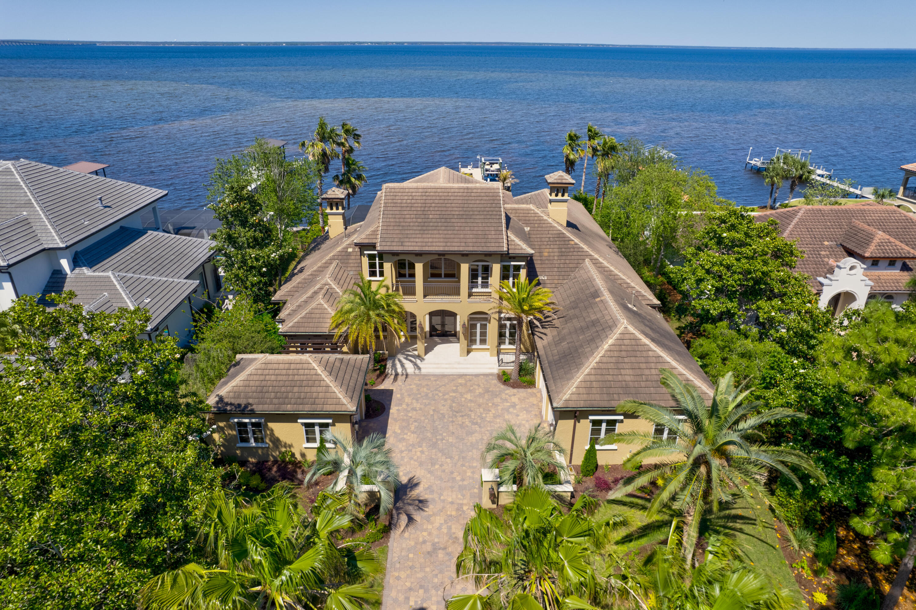 Coastal living at its finest. This beautiful custom built bayfront home is located in the gated community of Regatta Bay and features a chef's kitchen with custom cabinets, Thermador gas cooktop, GE Monogram double ovens, a large walk-in hidden pantry and an island with electricity. The luxurious bedrooms are complete with full bathrooms. There are cozy sitting areas and a second story game room with kitchenette. The screened patio features a summer kitchen, heated pool and hot tubs. The dock is equipped with water, electricity, 2 jet ski and 1 boat lifts. Call today to set your appointment for a viewing. Buyer to verify square footage.