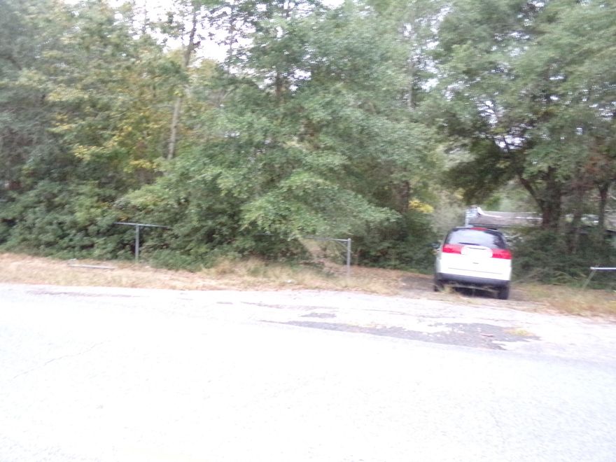 Over 2 acres on paved road in Baker with Milligan Water tap, electric & old septic tank~ There is an old house on this parcel that has been given no value~ This parcel would make a beautiful home place~