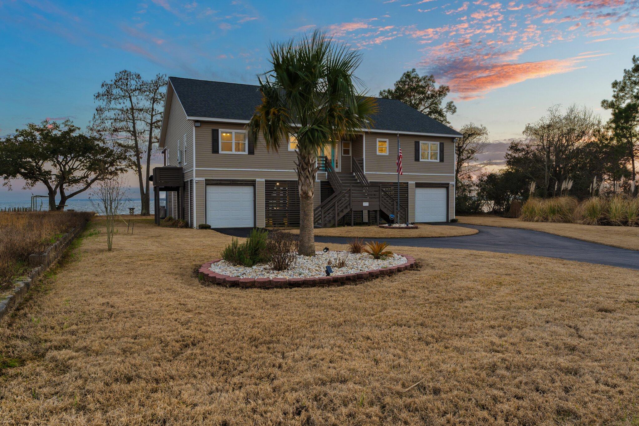 This beautiful beach home sits on approx 100 feet of private shoreline on Escambia Bay. With a white sandy beach, 300-foot boat dock with water & power, and a 10,000-pound boat lift it beckons you to live your dream. Bring your wave runner, kayak, paddle board, boat and fishing gear as this home is the perfect retreat to start living your relaxing Florida waterfront adventure. Outside you will also find amenities to enhance relaxation - a 750 sq ft covered patio with gorgeous sunset views, large yard, firepit, and an oversized 4 car garage with plenty of room to store water toys. The inside is just as spectacular. As you walk through the front door you are greeted with picturesque views of the water - you can feel the stress melt away. From the view to the soaring ceiling, to the Brazilian teakwood floor, to the fireplace, to the paint scheme and custom touches the open planned living area was built for entertaining and relaxing. The kitchen is a chef's delight with custom cabinets, imported quartz counters, stainless appliances, an large island, breakfasr bar and an oversized walk-in pantry. The luxurious master suite features a spacious walk-in closet with built-in shelving, a spa-like bathroom, access to the covered patio and breathtaking water views. The other 3 bedrooms and 2 bathrooms are appointed to the same standard and have unobstructed views of the water. Other important features include: 11 minutes to Cordova Mall or 25 minutes to downtown Pensacola but in the sought after Pace School District; 2024 roof & water heater; 2023 dock extension to access deeper water, paint & carpet; 2024 professionally landscaped, 2025 driveway; engineered for an elevator; a termite bond; and no property tax for 2025. At this price, waterfront living just makes sense - schedule your private showing today!