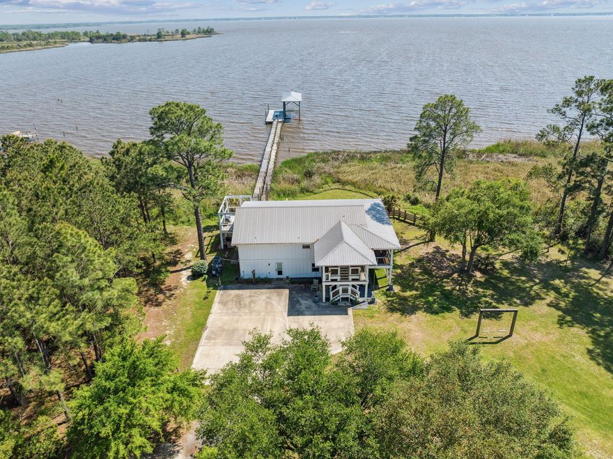 Nestled in a serene cul-de-sac, this stunning two-story bayfront retreat offers breathtaking sunrise and sunset views over the water. Thoughtfully designed for multigenerational living, the home features two distinct living spaces, each with its own private entrance.The first floor boasts a spacious one-bedroom, one-bathroom layout with a kitchenette, office, and expansive living area. Step outside to a covered patio where you can unwind while taking in the tranquil bay views.Upstairs, the main living space offers a bright and airy two-bedroom, two-bathroom layout with a full kitchen and a generous Southern-style screened porch--perfect for enjoying uninterrupted panoramic views of the bay. Wildlife enthusiasts will delight in the daily sights of dolphins, jumping mullet, soaring eagles, and graceful pelicans. For those who love boating and fishing, the deepwater dock, complete with a boathouse and lift, accommodates up to a 26-foot boat and provides easy access to the bay's premier fishing spots.

A picturesque, oak-lined driveway leads to this private waterfront haven, set on nearly three-quarters of an acre with 80 feet of pristine bayfront. Experience the charm of old Florida combined with modern comforts in this one-of-a-kind retreat.

The owners would prefer to sell this property in conjunction with MLS #974737 - 233 Shady Lane .