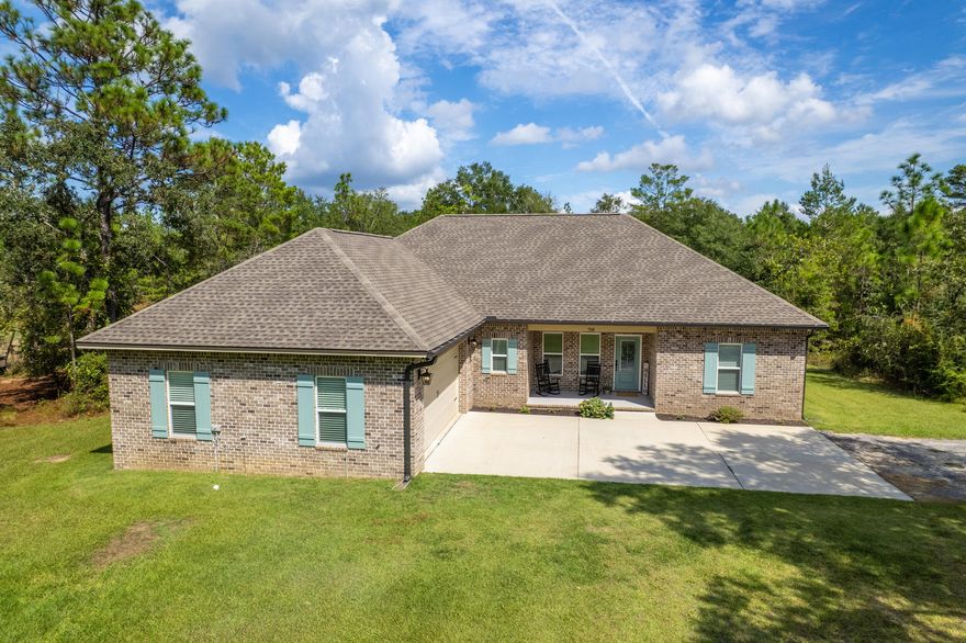Your search is over!  Check out this incredible custom-built brick Randy Wise home. Nestled on more than 8 wooded acres, you'll enjoy the perks of country living just a hop-skip from the many things that make NW Florida the best place to call home. Stepping into this open-concept floorplan, you'll see it lives large with 9 ft ceilings throughout, adorned with cove crown molding and classic Craftsman style trimmed windows--it's giving a luxe but livable vibe. The property boasts so many upgrades and amenities--it's hard to cover all of the amazing features!  The living room is prewired for surround sound, open to the kitchen and dining area, is flooded with natural light from the large windows.  And this kitchen... Chef's Kiss! Click to read more: The kitchen blends beauty and function with a walk-in pantry and  high quality Wood Harbor cabinets--soft close doors/drawers are finished with sleek black hardware, topped with granite counters and a classic subway-tiled backsplash. Professional grade Frigidaire appliances include a 36" gas cook top, wall oven/microwave, and refrigerator with ice in the door AND a second ice maker in the freezer drawer. The massive island holds the blanco undermount sink, has seating for four nestled under the bar. The pendant lighting and island's turned legs finish the look.  The adjacent dining space has access to the covered back porch, wired for surround sound, where you'll find a gas bbq connection for grilling out made-easy.  
The split bedroom floorplan offers privacy for the massive master suite, with tray ceiling and big windows overlooking your spacious backyard. Every day will feel like a spa day in this master bathroom with an integrated blue-tooth speaker-light: Custom tiled shower with frameless glass doors, three water options--rain-head, wall mounted shower head and a separate hand held shower head on the opposite wall; high window for natural light. The master bathroom has a separate throne room for the toilet, double vanity with clean quartz counter tops and an attached walk-in closet that conveniently connects to the laundry room. Every detail comes together perfectly to create your forever dream home.
The double car garage has a upgraded 18' garage door, finished epoxy floor, workbench, wall mount for your TV and an area for you to place your dart board! Need more space--say less! There is a nice storage shed with power and an overhang out back and an additional 18 x 21 carport. It gets even better: a separate 300 ft concrete driveway with RV pad plus turnaround, power & water behind some mature trees on the far side of the property! A place to park your RV or host company without needing to adhere to a 3 day rule! Your backyard has a space ready for your firepit. Want fresh eggs? not a problem--just bring your chickens to this move-in ready coop! 

About 8.5 miles to the I-10 interchange near Hwy 90 at 285. Approx 37 miles to the sugar-white sandy beaches of Destin; Only 18 miles to Historic Downtown DeFuniak Springs. You get the best of both worlds... easy commute to shopping, restaurants, schools while living your dream in your country oasis--complete with chicken coop and mature trees on a solid, regular shaped lot with 8 plus acres! Stop dreaming about it, you've found it!