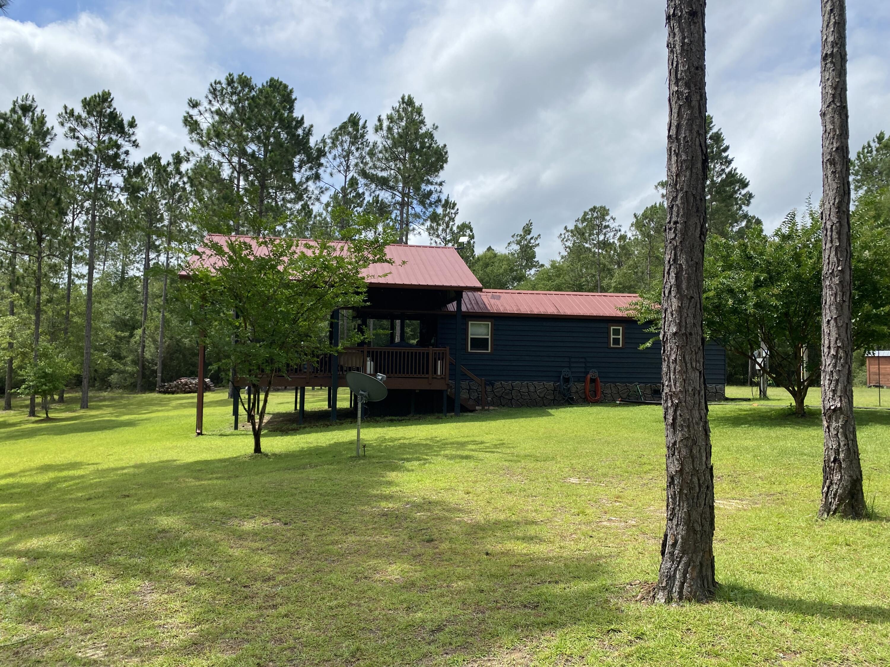 If you are looking for a turn-key ready, country cabin or home then this property is for you!  Located on 15.5 acres within Walton Plantation and having access to all the amenities of this development, this partially-cleared and fenced, creek-front parcel on Long Creek hosts a variety of improvements ready-to-use including a one bedroom, one bathroom cabin with expansive open porch, an open pole barn, an enclosed 1,200  SF workshop with electricity and concrete slab, a green house and a fire pit with circular swinging seating.   All the work has been done and this property is turn-key ready for you!