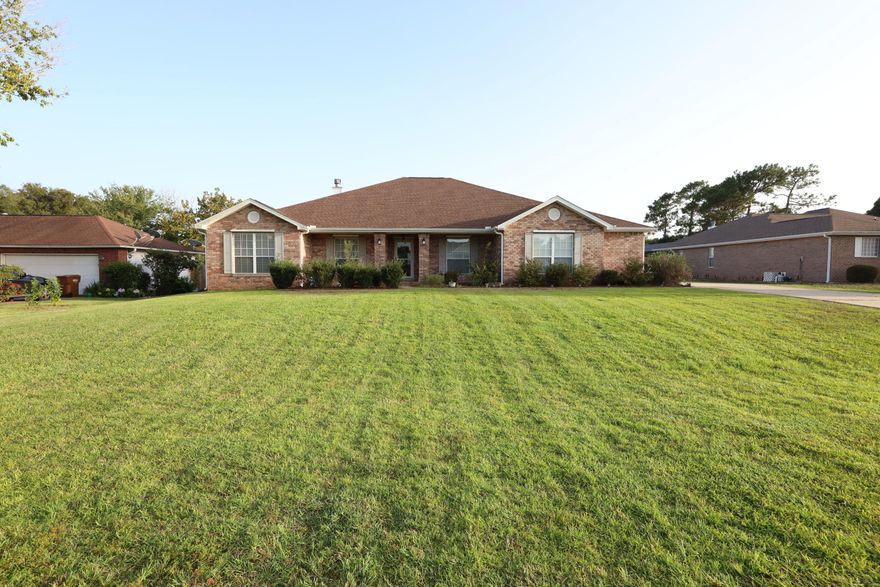 Escape to your own private oasis with this stunning 4 bedroom, 3 bathroom home that's situated a short distance from Navarre beach. This home offers a blend of relaxation and is enhanced by an array of sought after features. The sunroom serves as a serene connection to the outdoors overseeing a spacious backyard and featuring Glass sliders allowing you to bring the outdoors in. The main living space easily flows into the kitchen and dining areas giving you the ability to easily entertain. Enjoy the cooler weather with a fireplace located within the living area surrounded by built-in bookshelves. The kitchen features updated appliances, a center island, and ample storage in cabinets and a pantry. As you walk through the front entrance you will see two rooms featuring a home office and gym