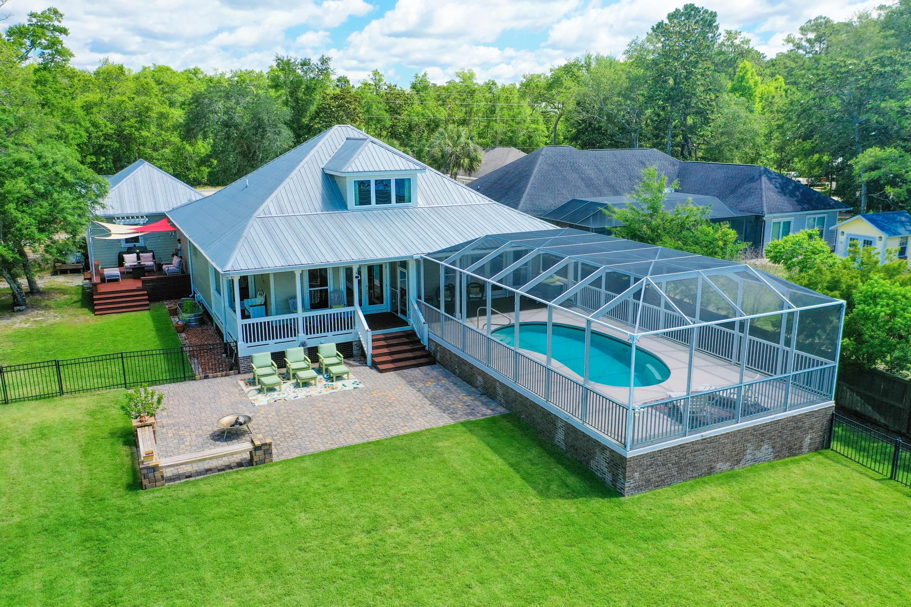Captivating, unobstructed bay views accentuate the beauty of this custom home. Very private and yet is conveniently located to restaurants, marina and shopping. Professionally landscaped yard w/large shade trees offers space for the home, screen enclosed pool, 3 car detached garage & workshop.  Enjoy watching the dolphins and osprey from the back  or side porch or on the dock which has a gazebo/covered boat slip w/lift. 2 bdrs/2baths are located downstairs w/a bdr/bath guest suite upstairs. A chefs dream kitchen w/oversized granite worksurface/bar. Floor to ceiling custom made cabinetry and the appliances are top of the line.  Gas Wolf cooktop, dbl ovens, Bosche dishwasher, icemaker, wine cooler - you name it, this kitchen has it. Hardwood floors throughout. Includes a full house generator