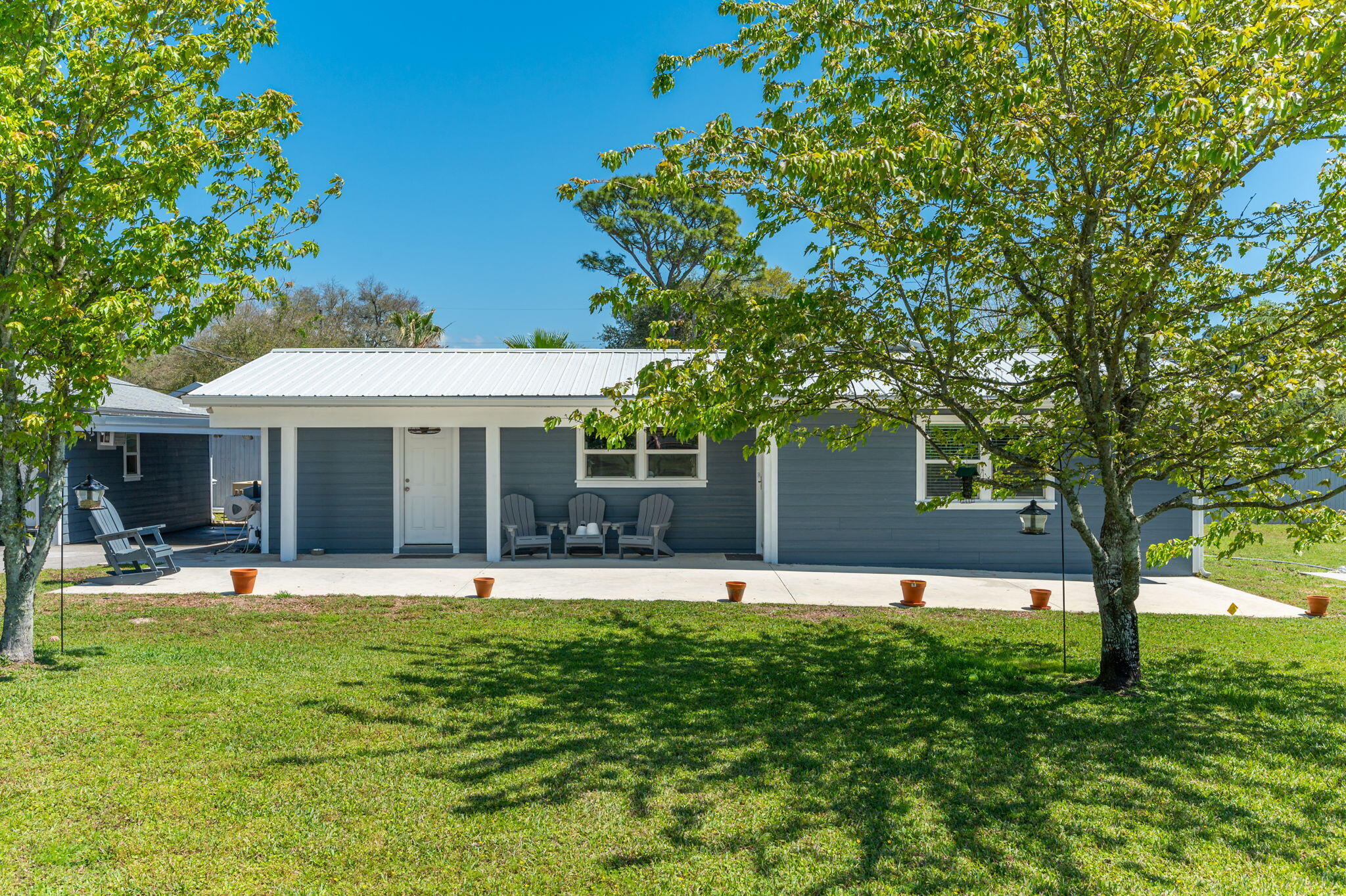 Welcome to a Florida Cottage Style home. This home features: 2,000 square foot, Metal roof, 3 bed, 2 full bath, with a office/extra room, with ''working'' Workshop, whole house Generac (gas) generator for those stormy days, and RV pad with electric and sewer hookups. Huge master bedroom, walk through master closet, tile throughout all the bedrooms and living areas, carpet in the master closet with a 2nd washer drier hook up, kitchen is fully remodeled, with pantry/laundry, and a fully fenced yard with open patio. We invite you to step into easy living.