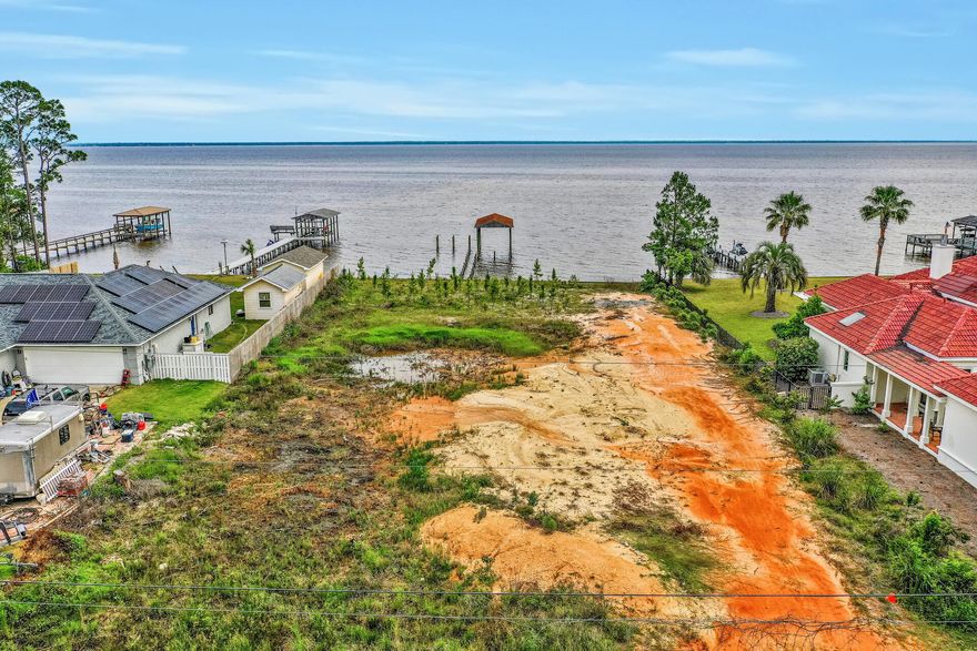 Build your dream home on 100 feet of gorgeous Bay frontage on one of the most desirable lots on exclusive Shore Drive.   Surrounded by large estates and homes with NO HOA, in the heart of Miramar Beach, shopping, schools, great restaurants & the beach are close by.  Large .58 acre lot has been cleared and shore-wall, dock pilings & roofed boat house already n place.