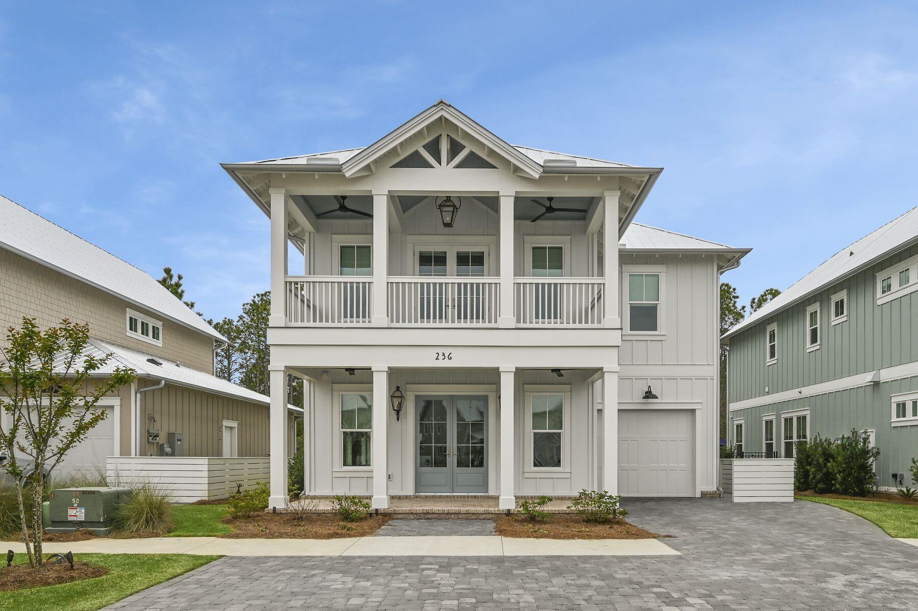 Nestled in the quiet coastal neighborhood of Cottage Grove, this recently-built home offers high-end finishes like brick porches and gas lanterns, spacious interiors and expansive outdoor living spaces backing up to preserved forest land all just a short distance from the beaches of Scenic Highway 30A. The first floor features hardwood flooring throughout the open kitchen, living and dining areas. The spacious kitchen offers an oversized center island, KitchenAid appliances, a gas range and hood, ceiling-height cabinetry and accent lighting along with a coordinating dry bar with a beverage cooler for added dining conveniences. A powder bathroom with accent tile, bonus room situated perfectly as an office or additional living space and one-car garage with storage solutions and epoxy flooring add to the many high-end upgrades. The covered back porch offers additional living space overlooking preserved forest land creating additional peace and privacy. The second floor features the master suite along with two additional guest bedrooms. The master suite offers vaulted ceilings, a private balcony, dual-vanity en suite, walk-in shower with custom tile and bench seating and a large walk-in closet. The guest bedrooms each feature a full bathroom with custom tile. The short-term rental-restricted neighborhood of Cottage Grove offers a gated entrance, community pool and community outdoor kitchen. The newly completed walking path provides an easy walking or biking commute to the Ed Walline Beach Access along with the dining, shopping and entertainment of Gulf Place and surrounding 30A communities like Blue Mountain Beach, Grayton Beach, Watercolor and Seaside.