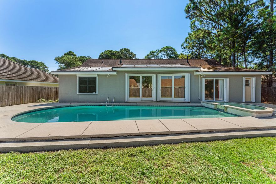 From the moment you enter this quiet, charming neighborhood you will feel at home. It is surrounded by lush trees and manicured lawns.  The stained glass front door allows natural light to sweep through the home. The open floor plan allows for views to the backyard from all of the entertaining rooms. The home boasts a well planned split layout allowing more privacy for the primary bedroom. The backyard boasts a fenced yard with a gleaming solar heated pool and hot tub .  Enjoy fresh bananas from your own banana trees.  One block from the home you are at the community dock where you can fish or swim in the community pool with your neighbors.  Golf cart friendly area with easy access to shopping, restaurants and the beach!

Buyer to verify all information.