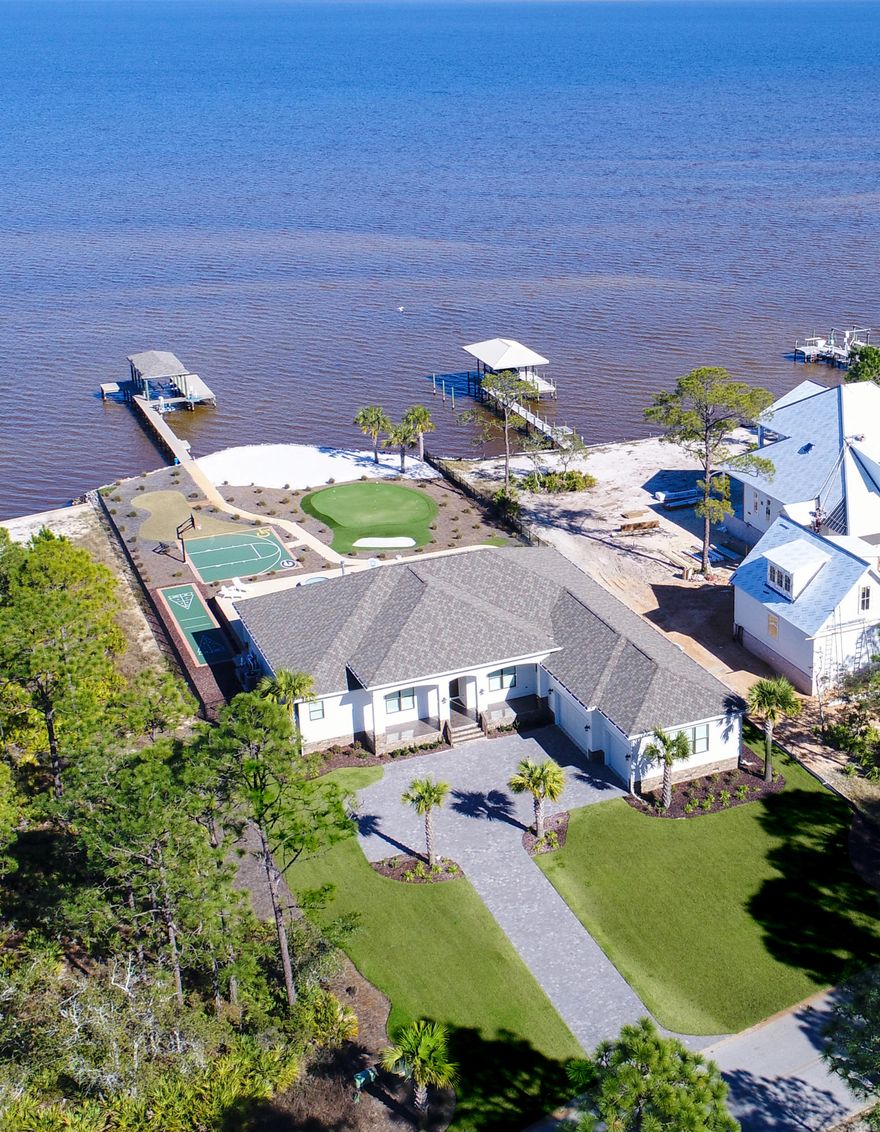 This incredible listing on the bay in beautiful Santa Rosa Beach is a dream home. Everyday here feels like living in your own personal resort. Sprawling and luxurious, the home features an open floor plan and a clean palate that feels lavish, yet comfortable. The well-appointed, impressive kitchen and oversized center island make preparing meals or entertaining a breeze. The master bedroom and en suite are grand and expansive, with the bedroom offering a fantastic view of the bay and backyard. The outdoor features of this home are extravagant, and truly like having the recreational amenities of a resort at your fingertips. A large private pool, hot tub, basketball and shuffleball courts, putting green with sandtrap, personal beach, and dock with boat lift are all yours to enjoy!