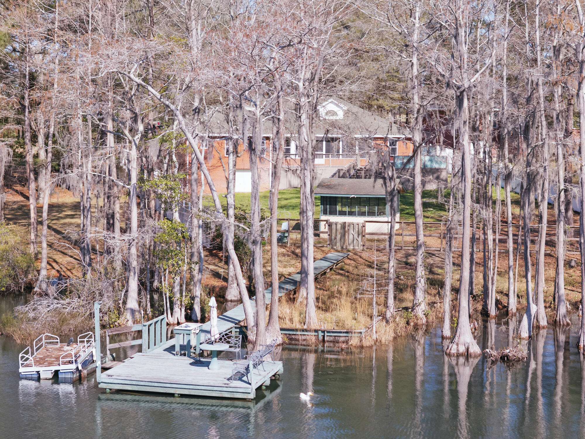 Every day is like a vacation when you live in this 2002 custom-built brick home on beautiful Blue Pond a natural sandy bottom freshwater lake perfect for swimming, fishing and scuba diving. Blue Pond is famous for its dinner plate size bream and record size largemouth bass. The 3-bedroom two bath home with attached 2 car garage includes an office, breakfast nook, formal dining room, stone gas fireplace in the living room, gas stove and a tankless hot water system. The back deck leads to the Endless Pool that gives you the fun of a pool plus the benefits of exercise. From the back deck you move to the grill house that is located steps away from the dock built over Blue Pond. Houses like this one don't come along every day. Shown by appointment