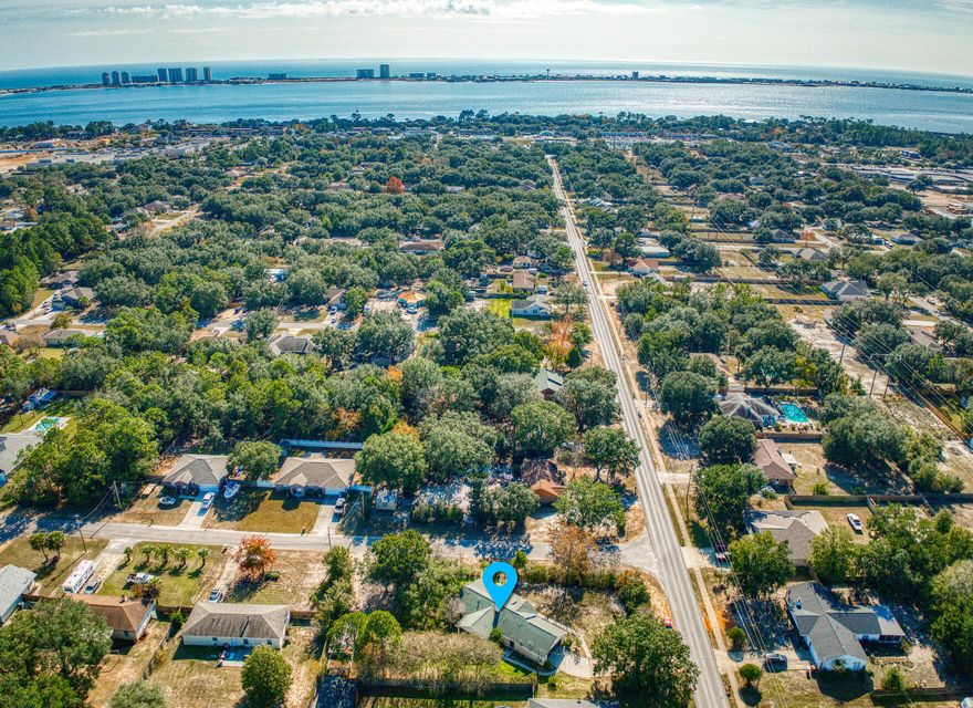 Wonderful, affordable Home on large .46 acre corner lot & ON SEWER w/2 car garage & large workshop.  Two separate driveways create ideal space for multiple vehicles/ boat/RV. You'll love the cozy great rm w/high, vaulted ceiling & angled gas fireplace.  Beautiful  new Quartz counters, freshly painted white kitchen cabinets & newer  LVP flooring throughout provide an updated look.  A gas stove too!  Offering a split floor plan, the big master w/walk-in closet is located away from other 2 BRs.   Enjoy the Fl lifestyle while relaxing on the large front porch & covered back patio. The huge, private backyard w/large, workshop provides plenty of room for play & a pool.  2016 roof & 2019 HWH.  Ideally located in the heart of Navarre, shopping, schools, beach & the base are close  by