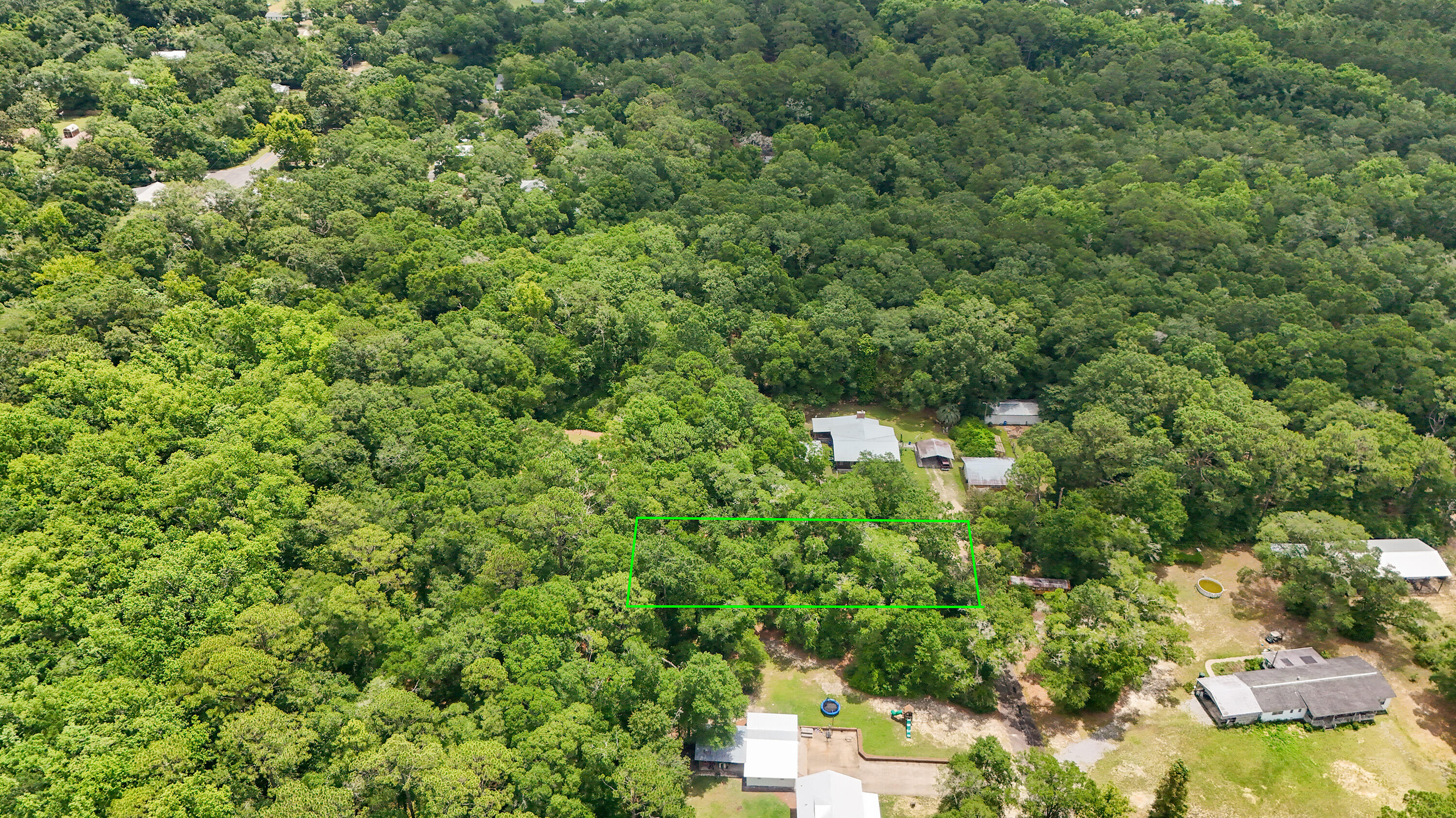 Rare, tucked away homesite in a well established neighborhood inside the city limits of DeFuniak Springs. Just a short walk or drive to Lake DeFuniak, and yet it feels completely hidden away in a serene setting. Wooded with availability of city water and city sewer and electric (taps unpaid). There is a 30' ingress/egress/utility easement over the easterly property line for the neighbors' access with about 50' in width for building.
