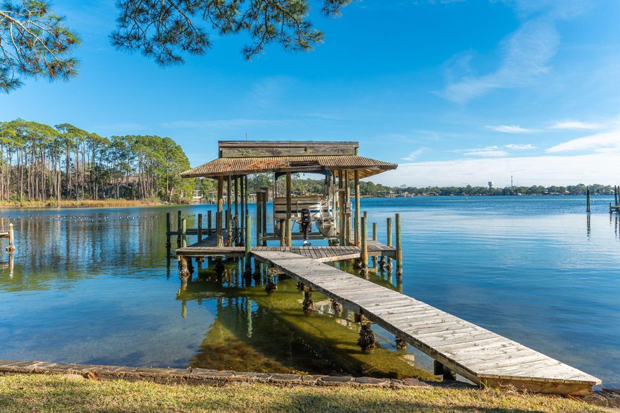 Nestled along the picturesque Poquito Bayou, this waterfront home is a serene retreat boasting a blend of Southern charm and modern amenities. The property is adorned with large trees draped in hanging moss, creating a timeless and tranquil ambiance. A spacious dock with a boat lift enhances the allure of the home, offering convenient access to the bayou's gentle waters. With two fireplaces, three bedrooms, and three full baths, the interior exudes warmth and comfort. A unique mother-in-law suite adds versatility to the layout, while floor-to-ceiling glass on the water side brings the outside in, showcasing breathtaking views. The lower level features a piggy-back garage, laundry room, workshop, expansive storage, and a storm shelter with a sturdy steel door. Recently updated kitchens and bathrooms boast stainless steel appliances, granite countertops, and modern fixtures. A balcony and sitting room provide the perfect vantage point to appreciate the bayou panoramas. Situated on a nearly half-acre lot, this family-friendly abode is part of a community offering amenities like a boat ramp, picnic areas, playgrounds, and more, ensuring a lifestyle that harmonizes with the beauty of its waterfront setting.