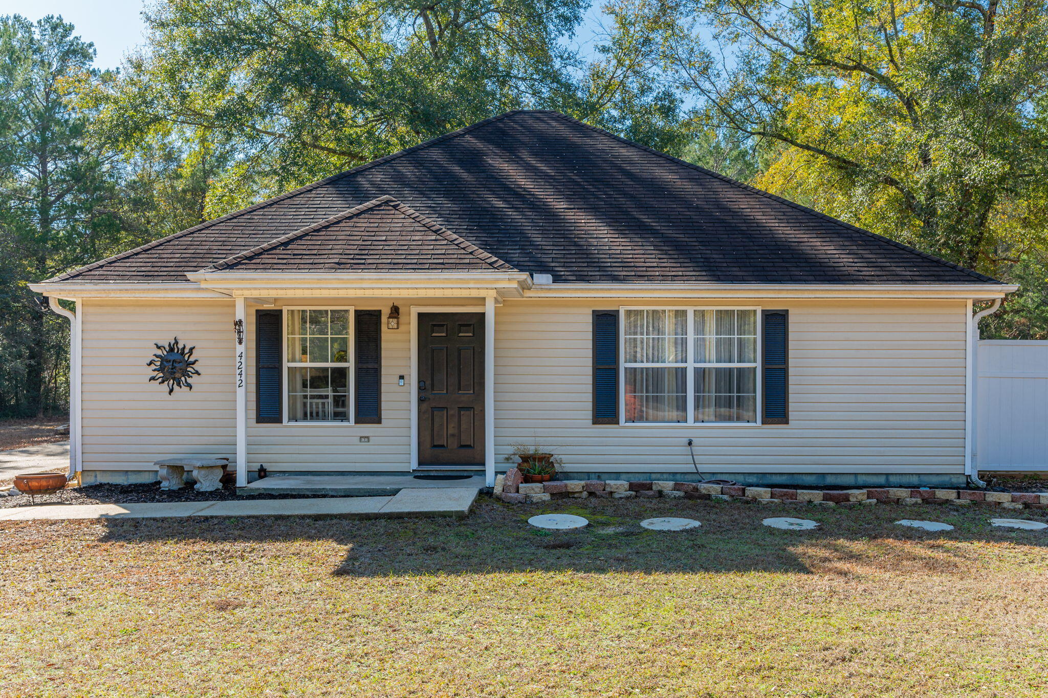 Oasis of secluded charm nestled on 1.16 acres, within minutes to shopping, schools, hospital and bases! Is 'land' and 'workshop' on your listing of must haves? This home is for you! This pretty gem has 3 bedrooms, 2 full baths, spacious laundry room & neat as a pin.  LVP and vinyl tile throughout. Not a fan of the custom vinyl? Not a problem, Seller has and is leaving the LVP to replace the black & white if that is not your style.  Large deck off the side to enjoy grilling, fire pit and sitting outside in the peaceful atmosphere. Notice the long extra wide drive to the detached garage/workshop...driveway has room for boat/RV or trailer with jet skis (whatever you want to park).  Detached garage/workshop has electricity & TV hook-up, possibilities are varied for use. There is a fenced area for pets and/or children to keep them close by.  Notes to keep in mind: Roof will be replaced prior to closing, HVAC 2023, Septic pumped inspected 2025.  Concrete yard d??cor & pots do not convey.  See it to love it!