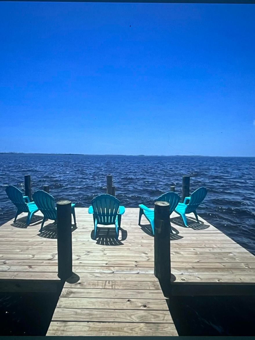 BAY FRONT/PRIVATE BOAT LAUNCH/GUEST HOUSE/HOT TUB/-Enjoy living on the bay for less than a million and No HOA! The home is currently a vacation rental, but could also serve as a primary residence or a second home. This gorgeous property with majestic southern live oak trees even comes with its own boat launch, so you don't have to drive to launch your boat. 155 feet of waterfront with 0.89 of an acre with sunrises and sunsets that will leave you breathless! The main solid brick house is 1852 sq. ft. with 3 bedrooms and 2 baths. The guest house is 504 square feet with one bedroom and one bathroom. The main house and guest house have been updated. The living area has beamed ceilings, LVP, and tile flooring throughout. The chef's kitchen is appointed  with a gas stove, white cabinets, and black Suede countertops, Thermador double ovens, tons of cabinets, stainless steel appliances, and a farm sink. A large breakfast bar for informal meals, and the dining area is large enough to seat the whole family. The open great room has floor-to-ceiling windows that overlook the bay with shiplap walls, pickled wood planking, and an open beamed ceiling. The living area is graced with a gas fireplace with German Schmear brick surround and eye-catching mantle. This home, with its open spaces, is perfect for entertaining. All the bedrooms have built-ins, closets, and drawers for storage. The owner's suite has a walk-in closet with a secondary step-in closet. The owner's bathroom has double sinks with a large tiled shower, a large copper soaking tub, and a sliding barn door. A large laundry room is located directly off the kitchen. The guest house has a kitchenette, full bath with tiled shower and floor, walk-in closet, and 2 lofts for loft beds. The guest house has a mini-split for controlled temperature. The garage has recently been turned into a Game Room, but can easily be converted back to a garage. This home on the bay has it all with almost an acre of land, its private boat launch/ramp, seawall, dock, hot tub, game room, and views of East Bay that are mesmerizing! Call for your appointment today! All measurements are to be verified by the buyer.