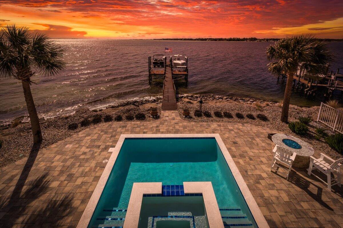Welcome to your dream waterfront paradise at The Pointe - a hidden gem nestled in a small, exclusive gated community on the pristine shores of the Choctawhatchee Bay in Shalimar, FL. If you've ever yearned for a life on the water with stunning panoramic views, sunrises, sunsets, boating adventures, dolphin watching and luxurious living, this 4290 sq ft, 4-bedroom, 4 bath 1 half bath masterpiece is calling your name! As you enter, you'll immediately notice the sheer quality and attention to detail that defines every inch of this home. Woodgrain tile flooring runs seamlessly throughout, setting the stage for elegance and easy maintenance. With an elevator servicing all three floors, this abode caters to the convenience of modern living, making it accessible to everyone. The house has been updated with fiberoptic internet for the fastest upload speeds possible. The first floor is a haven unto itself, featuring two spacious bay front bedrooms, kitchenette and living room with incredible water views that will have your guests never wanting to leave. This level also boasts a full handicap accessible bathroom and a full bathroom. French doors lead you to a covered porch. Picture yourself sipping your morning coffee while watching the bay come to life or enjoying a nightcap as the sun dips below the horizon.
Venture up to the second floor, and you'll be greeted by breathtaking water views from every angle. The living room, adorned with expansive picture windows, connects seamlessly to a large balcony, where you'll find the perfect spot to unwind, entertain, grill out or simply soak in the serene surroundings. This dream kitchen is complete with white cabinets, stunning leather granite countertops, a convection cooktop, and recessed lighting. A walk-in pantry adds an extra touch of practicality, making meal preparation a breeze. There is a bedroom with full bath and a conveniently located half bath for guests.
The entire third floor is a primary bedroom haven. Wake up to glorious water views, with recessed lighting setting the mood for your day. Two spacious walk-in closets plus a dedicated storage room provide ample storage. The master bathroom is a spa-like retreat, boasting tile flooring that expands into the stand-up shower with a waterfall shower head, a separate soaking tub, and a dual vanity with marble countertops. There are two rooms that can be off the primary bedroom that serve as his and hers computer rooms. French doors open to an expansive covered balcony
But it's not just the inside that will capture your heart. With 72 feet of Bay front property, you'll have a private dock, featuring two boat lifts and a fish cleaning station. The back yard also boasts an inground gunite pool/spa and gas firepit. You'll have unrestricted views access to Choctawhatchee Bay from anywhere you choose. Whether you're a boating enthusiast or simply love the idea of spending weekends exploring the crystal-clear waters, this is the perfect launchpad for aquatic adventures including crab island, numerous boat accessible restaurants intercoastal waterway and Destin Pass.