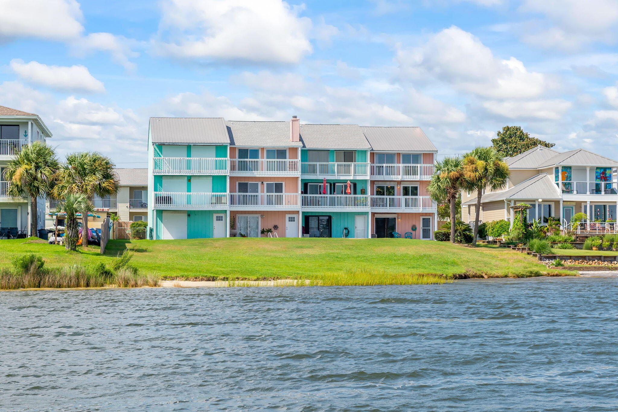 Beautiful 3 story END UNIT townhome with amazing VIEWS of the Sound from every floor! Enjoy the finest WATERFRONT living from your own BEACH, in-ground POOL, private PATIO, DOCK, or from multiple DECK BALCONIES! This home really has it all - including a BOAT SLIP with a LIFT! If you are looking for a great INVESTMENT property, second home or full-time residence, the interior has all the SPACE you need. This bright OPEN living-to-dining floor plan has an attractive FIREPLACE, 3 bedrooms ALL with ATTACHED FULL bathrooms, a guest half bathroom, HUGE kitchen with tons of COUNTER SPACE, oversized hop-up breakfast bar, and CUSTOM wood cabinetry. The FIRST-FLOOR bedroom could be a great game room, second family room, OFFICE or ENTERTAINING space as it opens up onto the PATIO and POOL area!