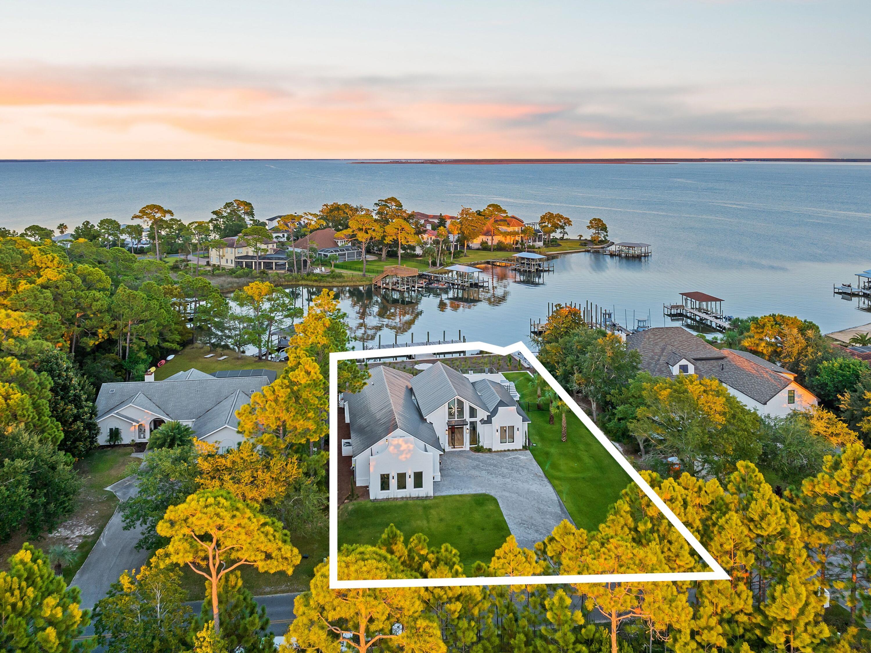 Boaters and entertainers will want to check out this stunning new bayfront home with its own private pool and carriage house. It goes beyond the norm with a deep-water dock, one of the last in Driftwood. The 60-ft. dock can easily accommodate a larger boat and offers direct gulf access via Destin Harbor. This contemporary home has a refreshingly modern facade with clean minimalist lines throughout, making good use of frameless custom glass windows and doors. The design boasts generous indoor and outdoor areas for entertaining, including 2,300 square feet of shell stone on the rear patio. The 30x12 pool provides a focal point for gatherings and has a rear balcony for elevated views across the sheltered waters of Choctawhatchee Bay.