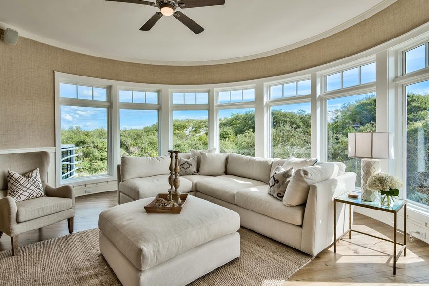 Compass Point in WaterSound Beach capitalizes on the natural beauty of sand dunes with tall sea oats to present luxury living in this thoughtfully-designed and well-crafted condo. Natural light streams into this stunning unit, with recently updated decor by Dwell Interiors. The kitchen opens to the outdoor balcony and boasts cream cupboards, stainless steel appliances and brushed nickel hardware. An inviting center island with a breakfast bar features the same granite countertops and faces the open living room and dining area. Perfect for entertaining, this space features hardwood floors, board and batten wainscoting, white trim against soft pebble walls and a curved wall of large windows with impeccable architectural details.