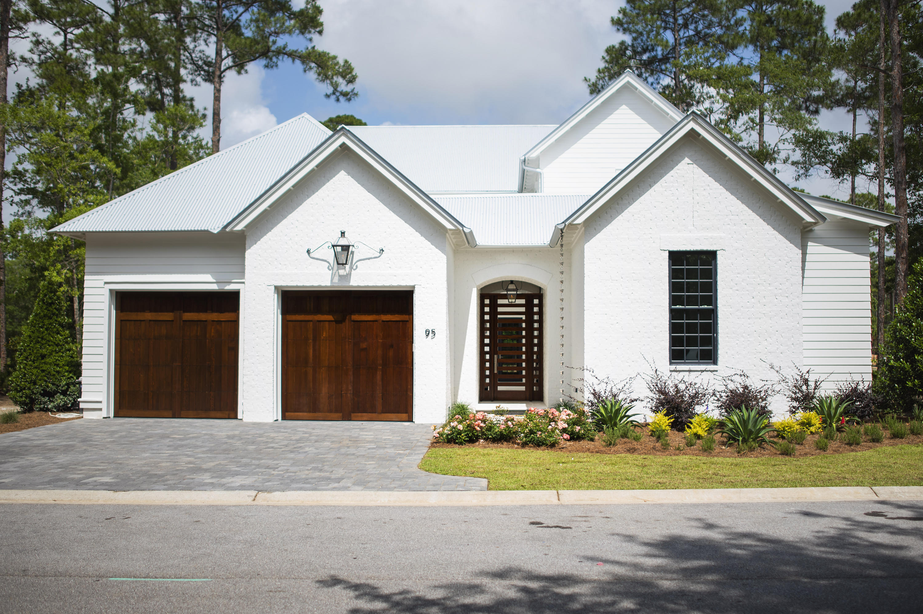 Newly completed within the gated Churchill Oaks neighborhood - This stunning Magnolia plan is designed by Savoie Architects and is situated on a beautiful spring-fed lake offering 4 bedrooms with the master on the main level, 4 and 1 half bathrooms, a 2-car garage with hardwood white oak floors, tongue-and-groove kitchen ceiling and Venetian plaster accent walls. The private courtyard with a pool, summer kitchen, loggia and lounge area offer endless summer fun without ever leaving home. The spacious first floor features an open living area centered around a modern ribbon fireplace and grand dining room with a full wet bar. The chef's kitchen overlooks the courtyard and dining area with beautiful quartz counters, slab cabinets, Thermador appliances + more high-end finishes.