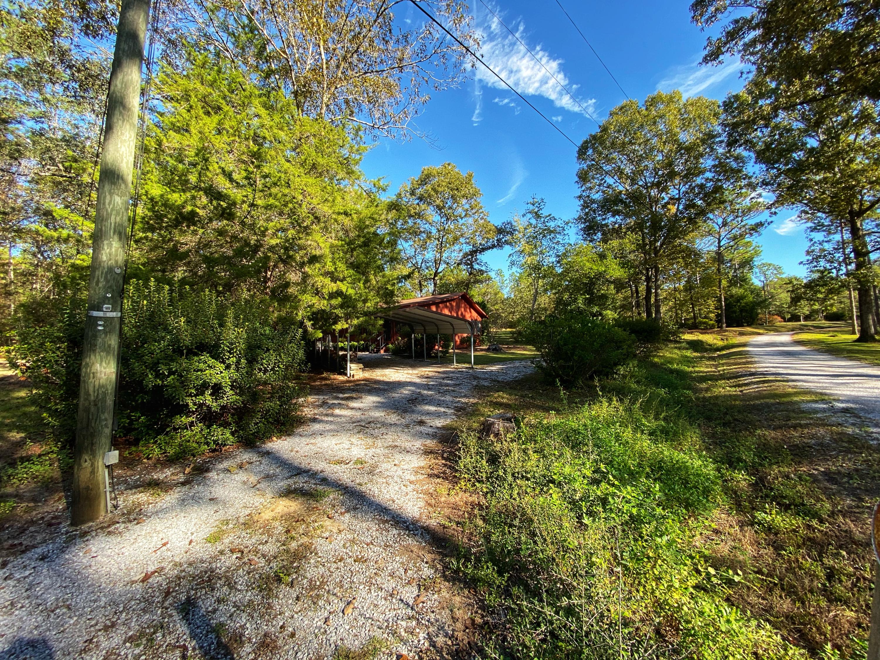 SO MUCH TO OFFER Charming, comfortable and cozy cabin style home on a little over 2 acres. This 2 bedroom 1 bath home features a big screened in front porch, perfect for family gatherings. There are many flowering bushes and trees located on the 2+ acres. Cozy up to the fire outside around the fire pit. This home is a must see!