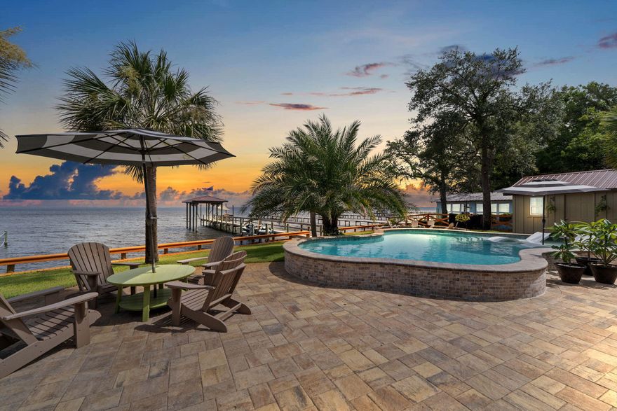 Step into the comfort of this well-positioned home in Gulf Breeze, located at 5938 E. Bay Blvd. This inviting 4 bedroom, 3 bonus room, 5-bathroom home boasts a generous layout including a large great room at the front and a cozy den with a fireplace at the back, perfect for relaxing while enjoying views of the Bay. The custom design was well thought out with details and precision during construction. The home is less than 4 years old and has over a half acre that is positioned to admire sunset views. There is 2 master ensuite rooms of your choice. One is on the first level off of the kitchen area and the other is upstairs for more privacy. The spa like bathrooms will have you feeling like you are on vacation for a lifetime.Half bath for the pool and outdoor guests and another