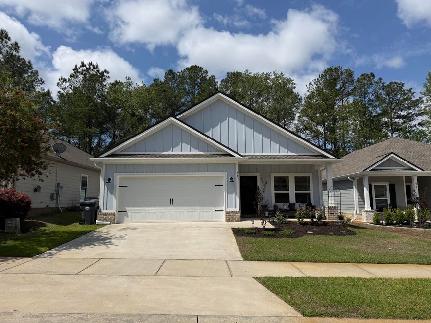 Built in 2024, this like-new home offers modern construction with thoughtful upgrades already in place. Cozy front and rear porches create the perfect setting for relaxing or entertaining, complemented by a privacy-fenced backyard, sprinkler system, and beautifully enhanced landscaping. Inside, the open-concept floor plan is highlighted by raised ceilings, recessed lighting, and LVP flooring throughout. The kitchen features a spacious work island with dining space, quartz countertops, contrasting white and black shaker cabinetry, stainless steel appliances, pantry, and a luxurious Bespoke Samsung refrigerator. The split-bedroom layout provides added privacy, with a well-appointed primary suite offering double vanities, a tiled walk-in shower with upgraded glass enclosure, a walk-in closet with custom buildouts, and a linen closet. Additional upgrades include plantation shutters, custom closet systems in every bedroom, added kitchen shelving, new door hardware, gutters with French drains, enhanced garden beds, and a digital front door lock--making this home truly move-in ready. The neighborhood features sidewalks, a community pool, and a prime location with convenient access to Hwy 20 and Hwy 331, as well as the nearby Publix shopping center. Just a 20 minute drive to the beaches of 30A!