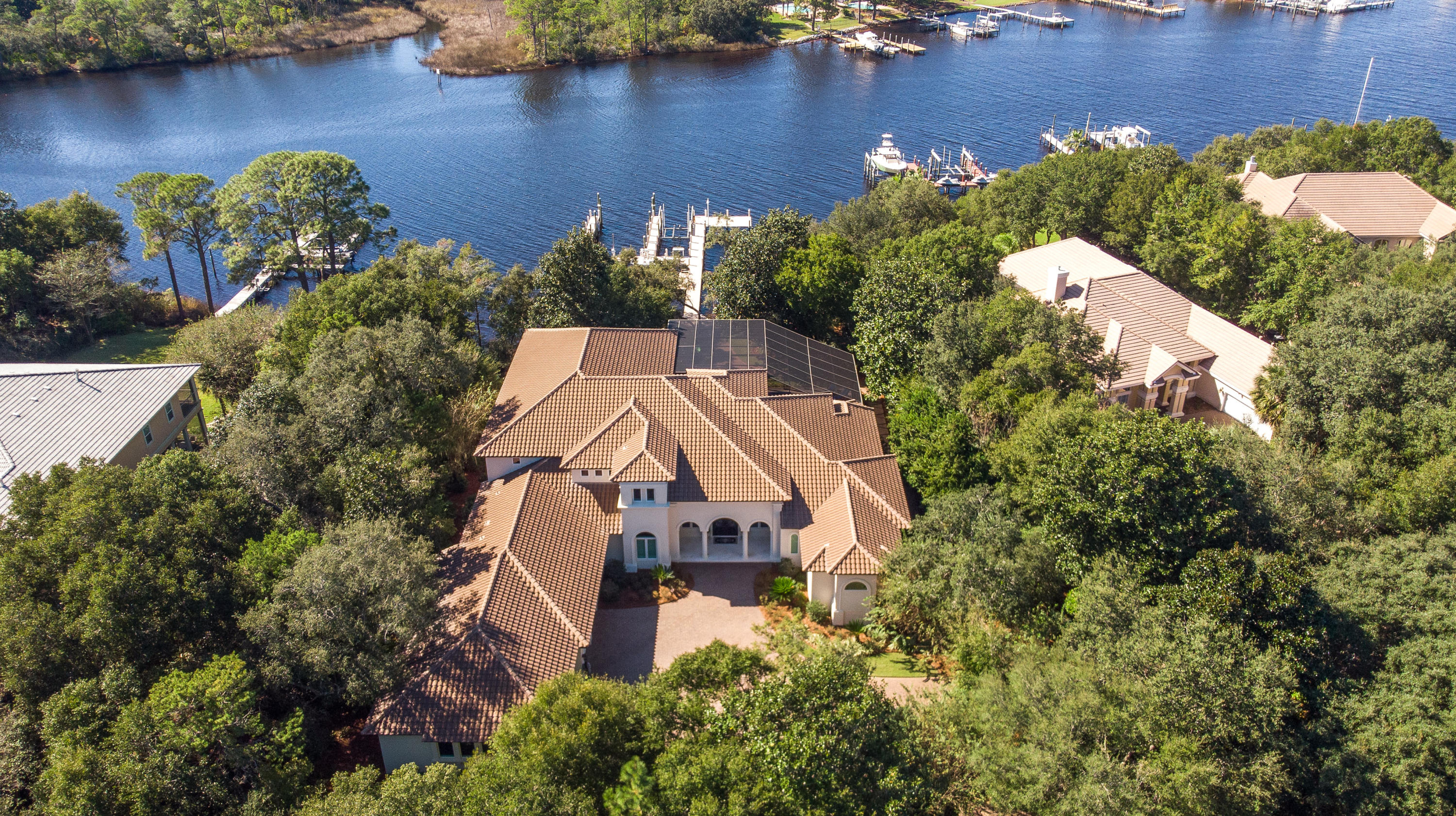 Perfectly positioned on a quiet cul-de sac in desirable gated Kelly Plantation, on one of the finest deep water lots in Destin!  Absolutely stunning one owner, custom home offers an unobstructed and protected view across the bayou, a high elevation and superior dockage....this is a boater's paradise!  Extremely private setting!  Fabulous Sater design features impressive double entry doors opening to a large gallery style foyer, a large living room and dining room.  To the left is a convenient wet bar, adjoining gourmet kitchen/casual dining/family room.  Soaring ceilings, large windows and sliding glass pocket doors allow for lots of natural light and direct access to the lanai.  Any cook will love this kitchen, with abundant cabinetry, granite counters, center island, upgraded appliances