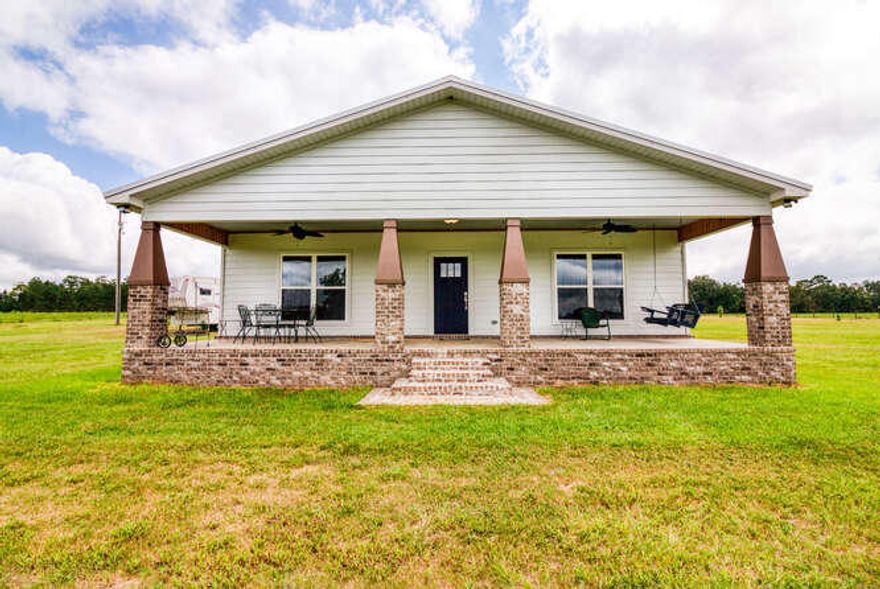 This custom built home is as good as country living gets! Located in the heart of Holt this home spares no details and is on just over 10 acres of cleared land. Built in 2019 offering an open floor plan which is perfect for the entertainers. This house is 2 bedroom 2 bath with an over sized laundry room and offers stained concrete flooring throughout the whole house. Kitchen displays all stainless commercial appliances including a 4 door freezer/refrigerator and 6 burner gas stove top with oven located in the bottom. Convection/microwave oven with a matching oven underneath totaling 3 ovens in the kitchen! A spacious breakfast bar wraps around with granite counter tops in the kitchen as well as a very large granite island in the middle of it all. Right off the kitchen is the living area housing over sized double pain windows which almost stretch from ceiling to floor with a raised wood tongue and groove ceiling. Features a walk in closet in the master bedroom as well as a very spacious second closet. This home features 2 split unit ac units that cool the living ,kitchen and dining and a regular air handler/condenser unit that cools the 2 bedrooms and laundry room.