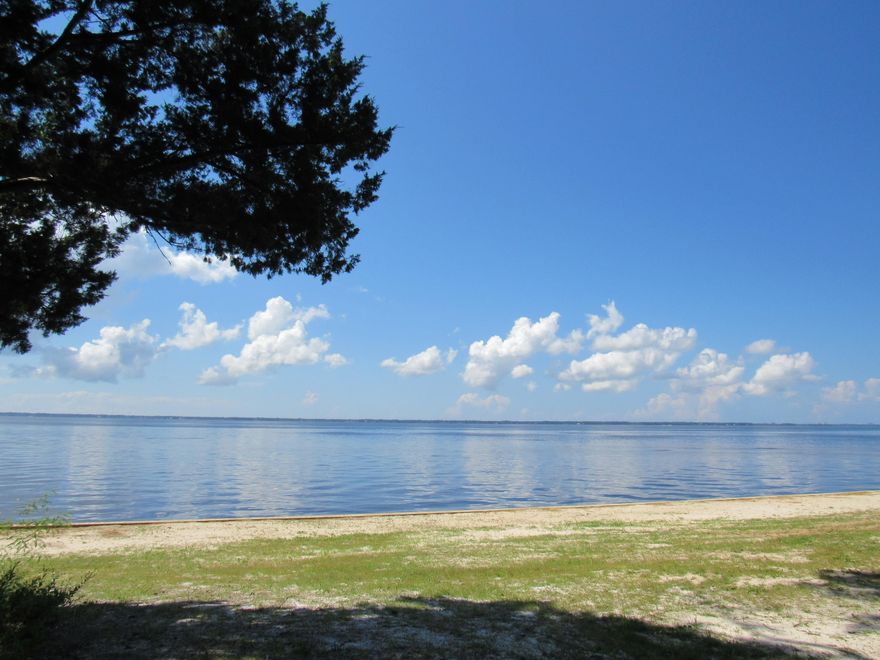 PRICE REDUCED! Simply the most beautiful bay front lot on the market today. Amazing sunsets and bay views await you on this large .72 +/- acre waterfront lot with approximately 176 +/- ft. of waterfront. This property has improvements including a new seawall, 14x24 ft. detached garage/workshop, utilities (electric, public water and older septic) and is partially cleared. Many beautiful native shade trees adorn the property including magnolia and oak trees. There is an older model mobile home on the property that was given no value. This is the perfect lot to build your dream home! Private and is only 15 minutes by boat to crab island/Destin, Fl. Don't miss out, call today!