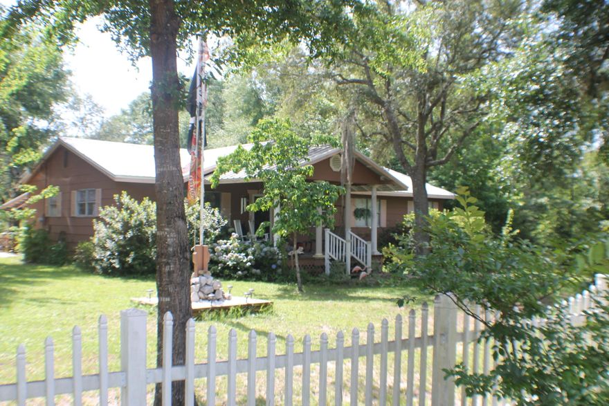 Two Homes for the price of one! White picked fence,Mossy Oaks huge rocking chair porches! These homes are on a paved road and an acre! Bring the in-laws or rent one out! Mobile home in the back (2 bedroom 2 bath) has its on address! The shade trees and the coy pond make a great place to relax and BBQ! There are two lawn sheds, a detached garage with a shop area and an R/V barn with a carport attached! Brng the family and the toys! Southern Living and Relaxin! Home Sweet Home(s).