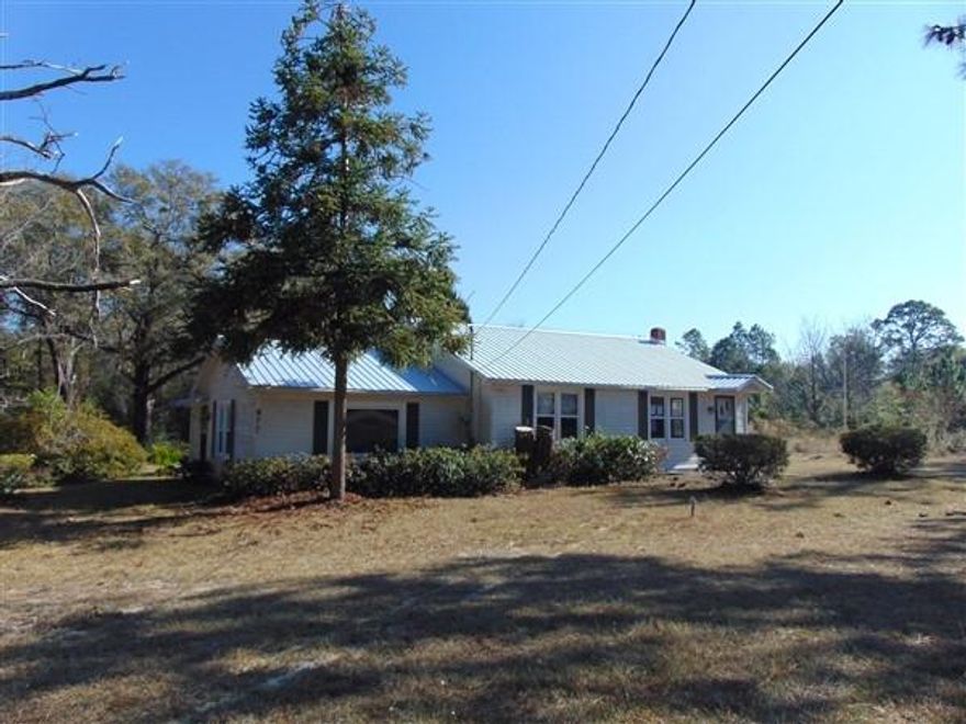 Country home on 3 acres just under a mile from Lake Defuniak and historic Defuniak Springs. Detached 2-car garage/workshop, additional storage shed and 6x18 open deck. Much of the interior walls are beautiful knotty pine. Home has double pane windows, central H&A, new roof in December 2014. Living room at front and separate entrance into family room with bonus area. Great location...schedule your showing today!