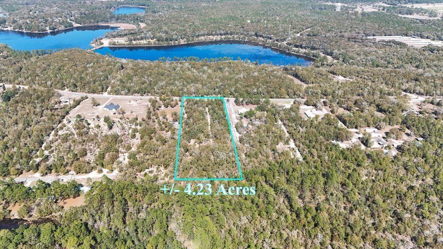 4.23 acres, private homesite already carved out under gorgeous mature oaks, and you can't see it from the road. Follow the drive back to a level, park-like clearing ready for your build. Temporary power pole is in place. Existing well present but not warranted; city water available at the road with tap fees due. Rural Village zoning allows manufactured homes and up to TWO UNITS PER ACRE, perfect for homestead plans, multi-generational living, or income potential. Quiet country feel just 5 minutes north of downtown DeFuniak Springs. Bring the plans, the animals, or the family - or all three!