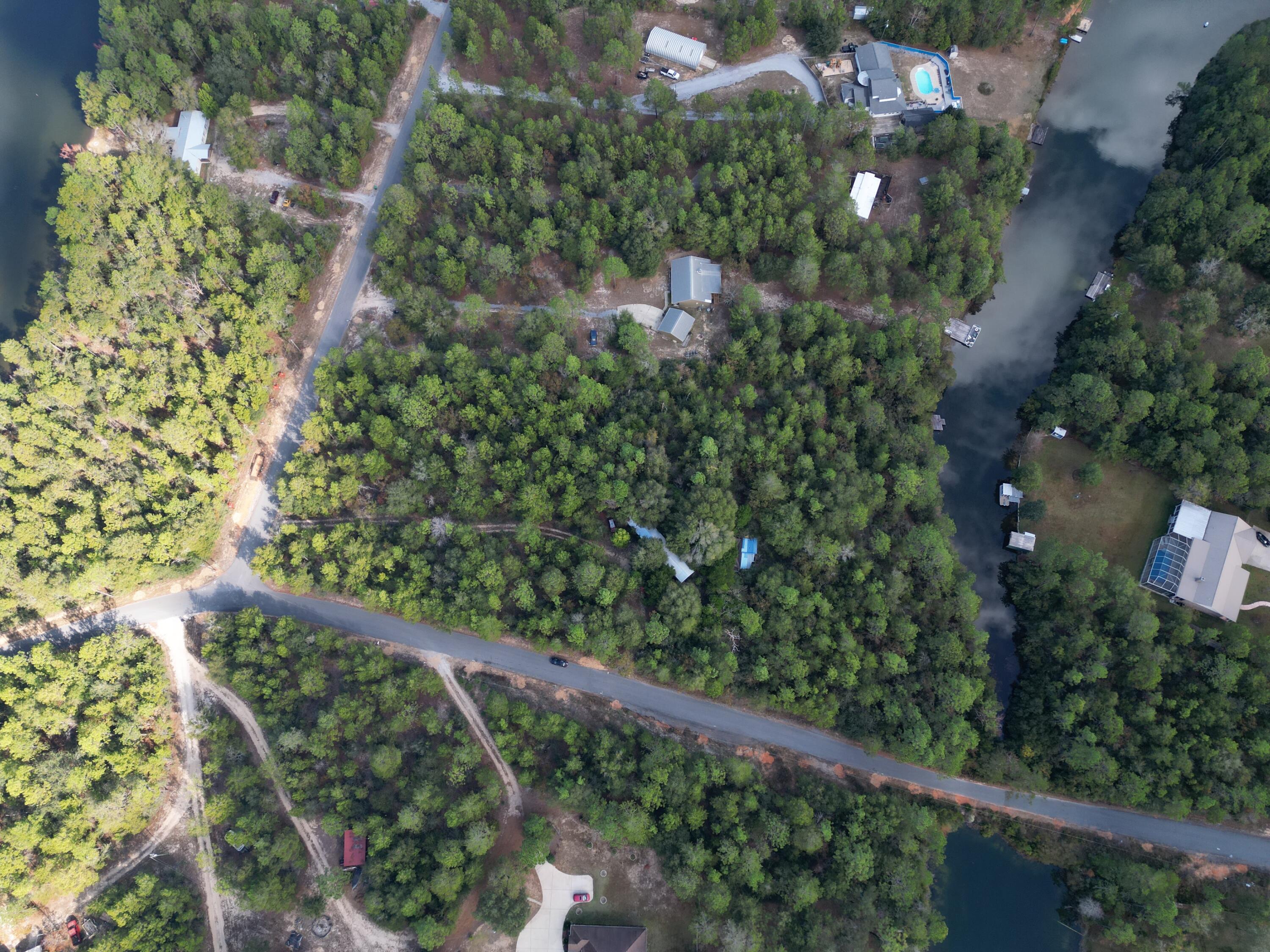 Bring your home plans and create your future! This property is being sold AS IS with over 2 acres of land, tons of waterfront on the lake, and surrounded by beauty with plenty of foliage for privacy. This property currently holds two structures and is hooked up with electric, city water, and sewer. Structures will be sold AS-IS.  Easy access to both Crestview, Defuniak, Niceville (via 285), and the local military bases. Schedule your showing today! Buyer to verify all areas of importance.