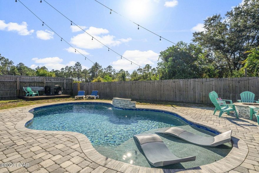 UNDER CONTRACT WITH CONTINGENCIES; SELLER ACCEPTING BACKUP OFFERS.
Completely remodeled and renovated, 3 bedrooms plus bonus room and 3 bathrooms, home located in highly desired Colony Club only 1200+/- feet from the Bay and less than 5 minutes from Surfside Middle School, Hutchison Beach Elementary, and Arnold High School. This home boasts 2,999 square feet under roof on a massive lot boasting close to half an acre. Each bedroom has its own bathroom and is large enough to accommodate king sized bedroom furniture and the master bedroom closet is a huge 12 x 8 feet. The owner has spent $10s of thousands of dollars modernizing this home and making it into a one-of-a-kind showcase home, perfect for a large family. The living room has vaulted, soaring wood ceilings with two skylights accentuated by terracotta tile floors and a wood burning fireplace.
The kitchen is state-of-the-art with a walk-in pantry with all new quartz countertops, new custom backsplash, freshly painted custom cabinets, all new stainless steel appliances, and new wine fridge. The kitchen, living areas, and bedrooms are all accentuated with brand new pendant lighting, and new carpet in the bedrooms. The roof was recently installed with architectural shingles, and the solar panels have been paid off and contribute to an energy efficient home with an ultra-low electricity bill. A brand new well pump for the home was recently installed boasting 65 pounds of pressure, two brand new HVAC units including a 4-ton unit that controls main living areas, 2 bedrooms and 2 bathrooms - the 2-ton unit is for the master bedroom - and mini-split HVAC unit is for the garage which can be used as a 4th bedroom), and all new HVAC duct work throughout the home. The large 27 x 8 covered back porch overlooks a pool deck and pool that rivals homes on 30a with a pebble sheen pool surface (mother of pearl), and a lifetime warranty. The pool has Pentair Universal Color Logic LED lighting with 10 fixed colors & 7 color changing light shows. There is also an outdoor fire pit and grilling deck. An atrium was built in the front of the home for entertainment with a quiet refuge for reading a book or enjoying a cup of coffee. This home is wide open and flows seamlessly from room to room and is perfect for entertaining family and friends. All doors have been upgraded with digital locks. The outside of the home has two showers and a storage building for lawn or pool equipment. The driveway is oversized with plenty of room for parking multiple vehicles, boats, etc. This home is like nothing you have ever seen with modern upgrades. Walking distance to Gayle's trails, short drive to Pier Park, Holiday golf course, great restaurants and schools. Make this state-of-the-art home yours today.