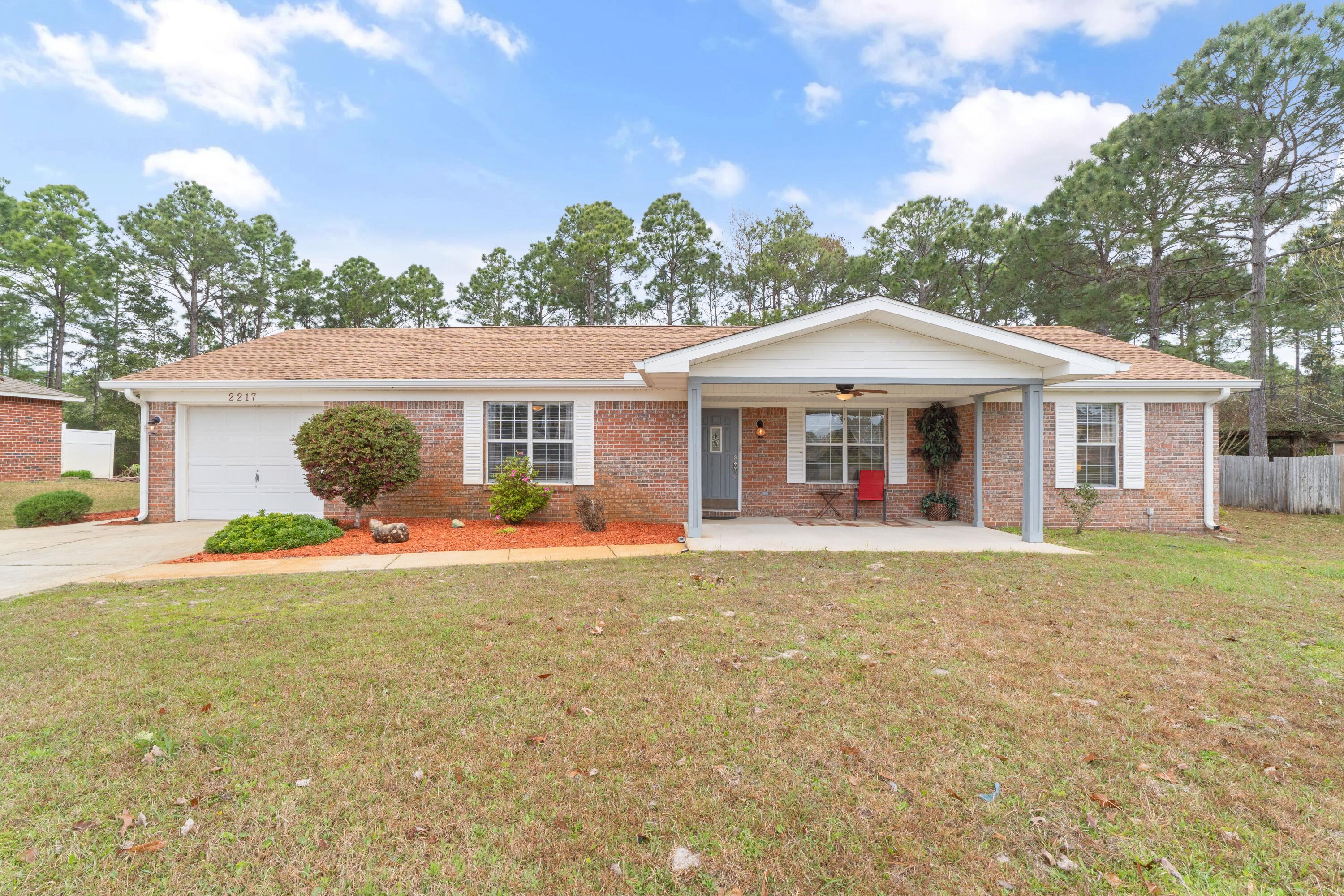 In the heart of Holley Navarre's serene neighborhood, this all-brick residence wrapped in vinyl trim stands as a beacon of low-maintenance living. A spacious double-wide driveway welcomes you, leading to a home nestled amidst a sprawling front yard, creating an inviting retreat from the hustle and bustle. Inside, this three-bedroom, two-bathroom sanctuary is designed with comfort in mind, featuring a convenient utility room off the kitchen for seamless living. Just two miles from the beach, the allure of the gulf is never far away. Perfectly positioned for families, with easy access to top-rated schools, Publix, Starbucks, and breathtaking Navarre Beach, convenience is just a part of life here. Recent enhancements including a new roof in 2023, a modern HVAC system, an efficient (cont.)