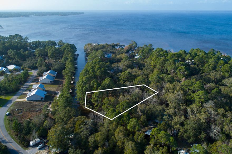 This is a spacious waterfront lot just under 1 acre in size, ready to build your dream home. Amid towering trees and natural woodlands, you'll not only have privacy, but also the privilege of putting your boat, paddle boards, and kayaks into the deep water canal that borders the lot and connects with Choctawatchee Bay. One neighborhood boat ramp is located at the end of the street with another one just east of the property. This homesite is conveniently located close to Gulf of Mexico beaches, Grand Boulevard shops, restaurants and entertainment, and Sacred Heart Hospital.