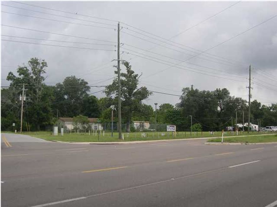 Great high traffic corner (31,982 cars per day), commercial lot with 440+/- front feet of road. Water and sewer tap in place. Fire plug on right-of-way . This is prime four lane frontage with a high traffic count. The County Offices, Fairgrounds, and multiple businesses bring the traffic in. This lot is cleared and ready for ownership or future development. The existing structures convey as is with no value implied. This three bay service shop and portable office building are in need of removal or remodel. The high security fence conveys with large gates designed for an 18-wheeler to pull through in a circular fashion.83 acres.=