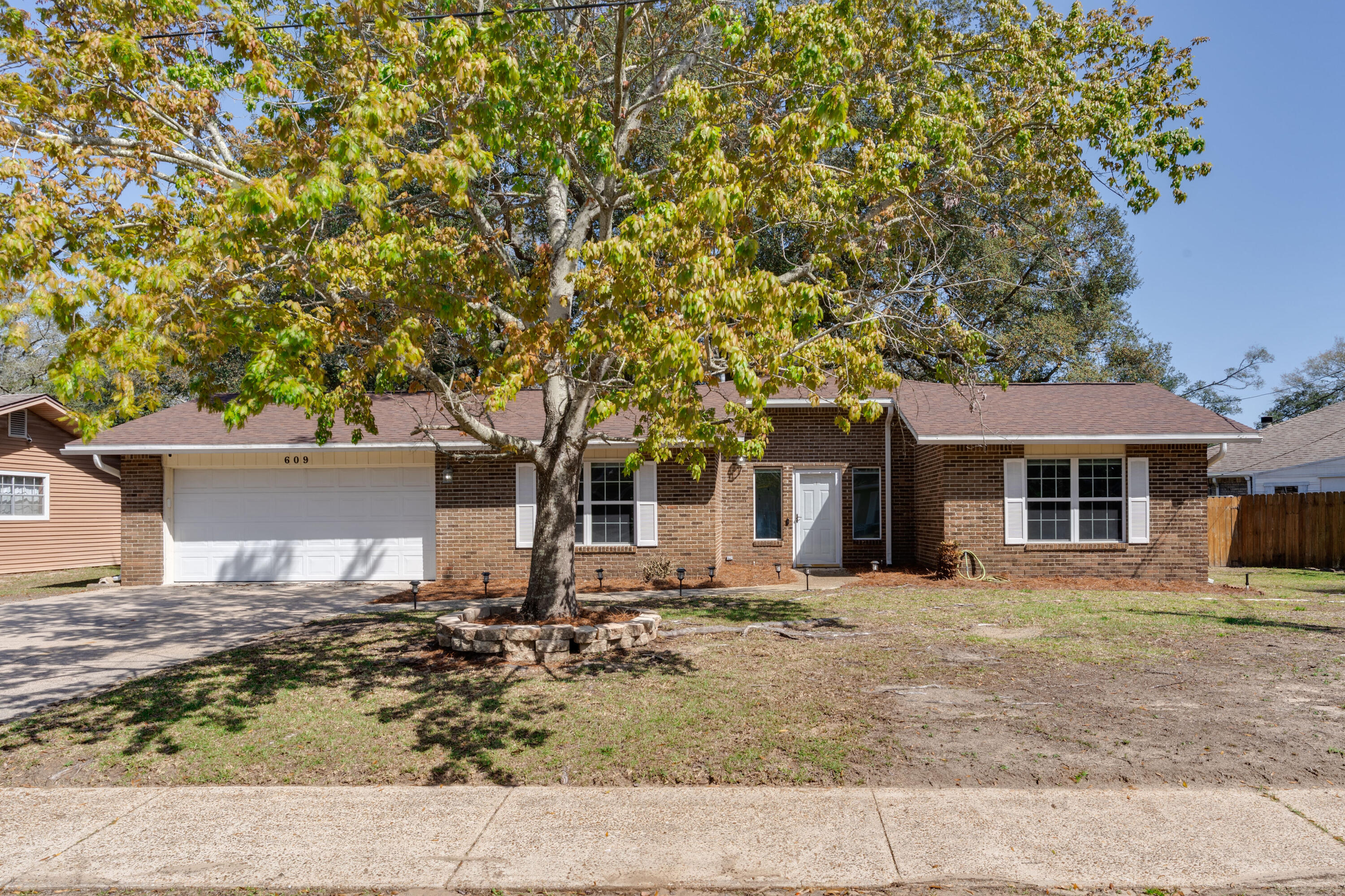 This beautiful home is right in the middle of all that Fort Walton Beach has to offer but feels like you are in a park setting with a large yard filled with mature landscaping and huge old Oak trees.  This beautifully renovated three-bedroom & two-bathroom home is move in ready with no detailed overlooked. From the paint and new flooring, right down to the custom wood trim and brand-new electrical switches and outlets throughout. The well-appointed kitchen with breakfast bar opens up to the dining area with fireplace, that then leads to the TV & living room.  A perfect floor plan to entertain guests, raise a family and enjoy quiet nights at home in front of the fireplace. The large primary suite has a newly renovated attached bathroom and a large walk-in closet.  With two additional bedrooms, a second full guest bathroom and an attached garage, makes this home perfect for a growing family or a second home here on the beautiful Emerald Coast of Florida.