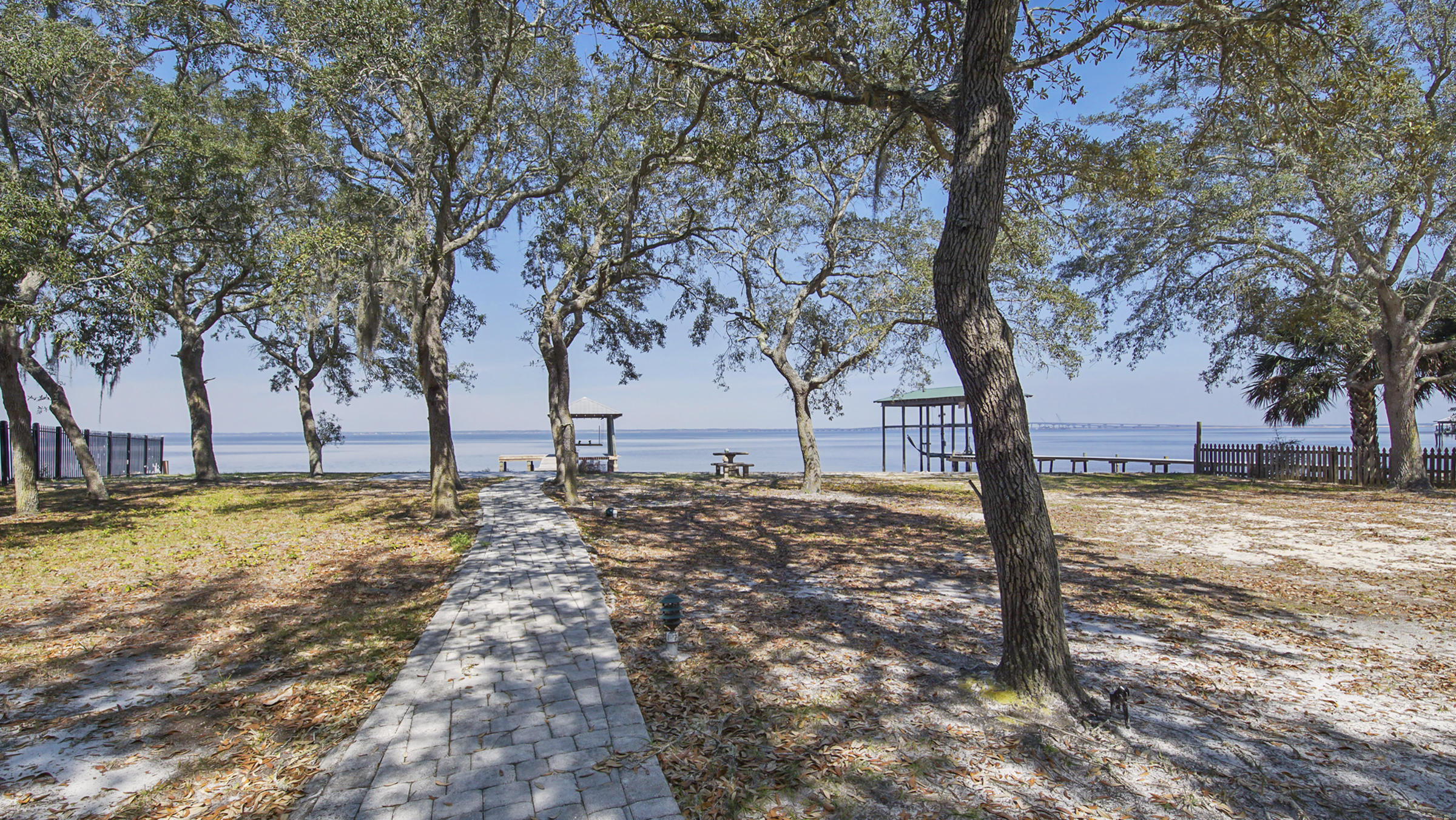 Waterfront lot located in Bay Pines Subdivision. Private setting within this small bay front neighborhood. Lot does have an existing 1 bedroom brick cottage that is fully functional and very quaint. A one car attached carport is perfect for boat storage and is next to a nice brick storage building. A separate carport is just off the drive as you enter the property. There is also a nice free standing screened in shade pen. Pavers provide a nice path to a shore side sitting area patio. All 123 feet of waterfront has a seawall with rip rap added. There is a newly updated dock that includes a covered boat lift. A well is in place and just needs a pump and irrigation line to be functional. This beautiful property is ready for that bayfront dream home
