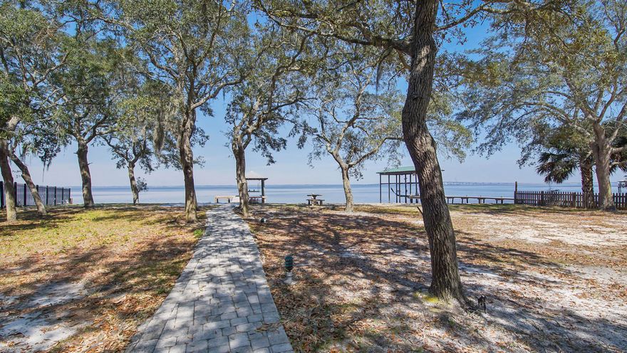 Waterfront lot located in Bay Pines Subdivision. Private setting within this small bay front neighborhood. Lot does have an existing 1 bedroom brick cottage that is fully functional and very quaint. A one car attached carport is perfect for boat storage and is next to a nice brick storage building.  A separate carport is just off the drive as you enter the property. There is also a nice free standing screened in shade pen. Pavers provide a nice path to a shore side sitting area patio. All 123 feet of waterfront has a seawall with rip rap added. There is a newly updated dock that includes a covered boat lift.  A well is in place and just needs a pump and irrigation line to be functional.  This beautiful property is ready for that bayfront dream home